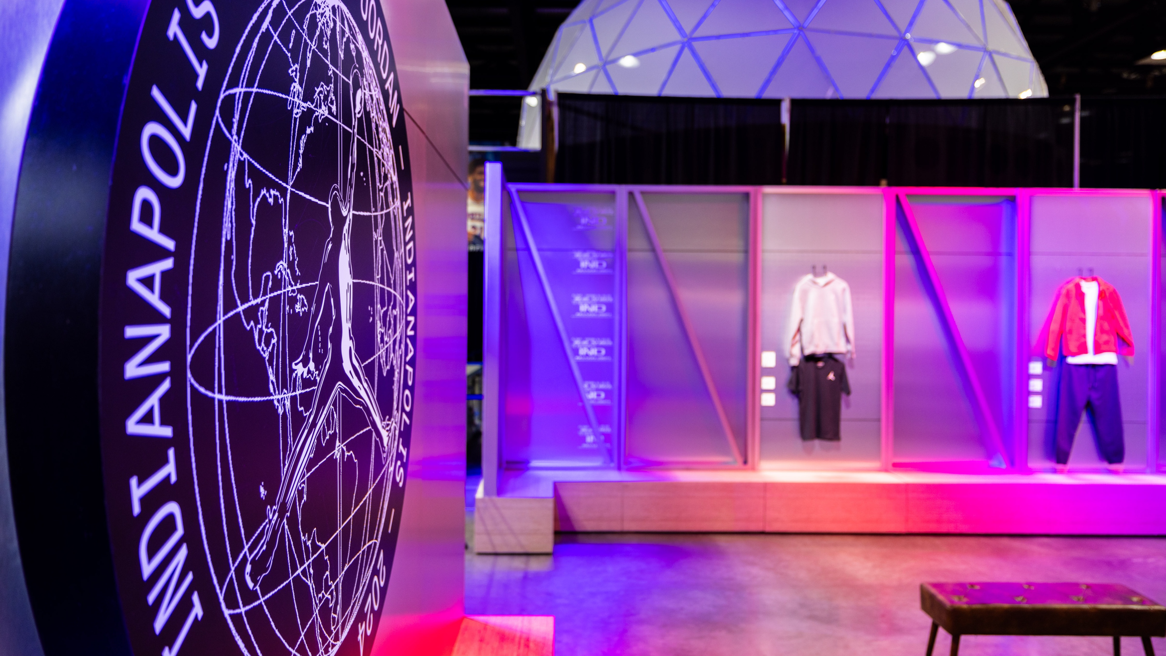 Close up of signage in front of pop up brand activation stools and clothing modelled on mannequins