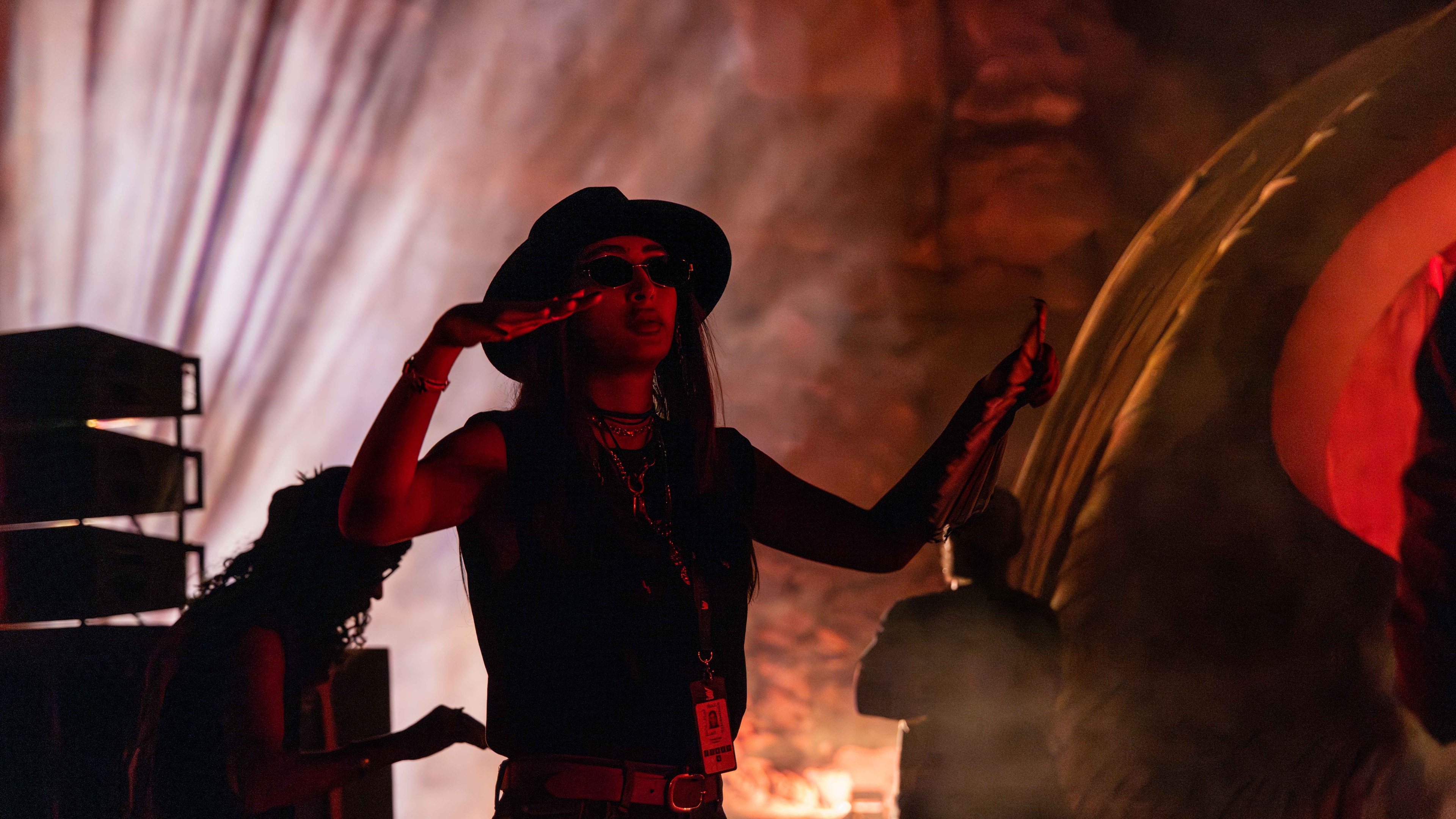 woman wearing hat and sunglasses at festival low lighting setting