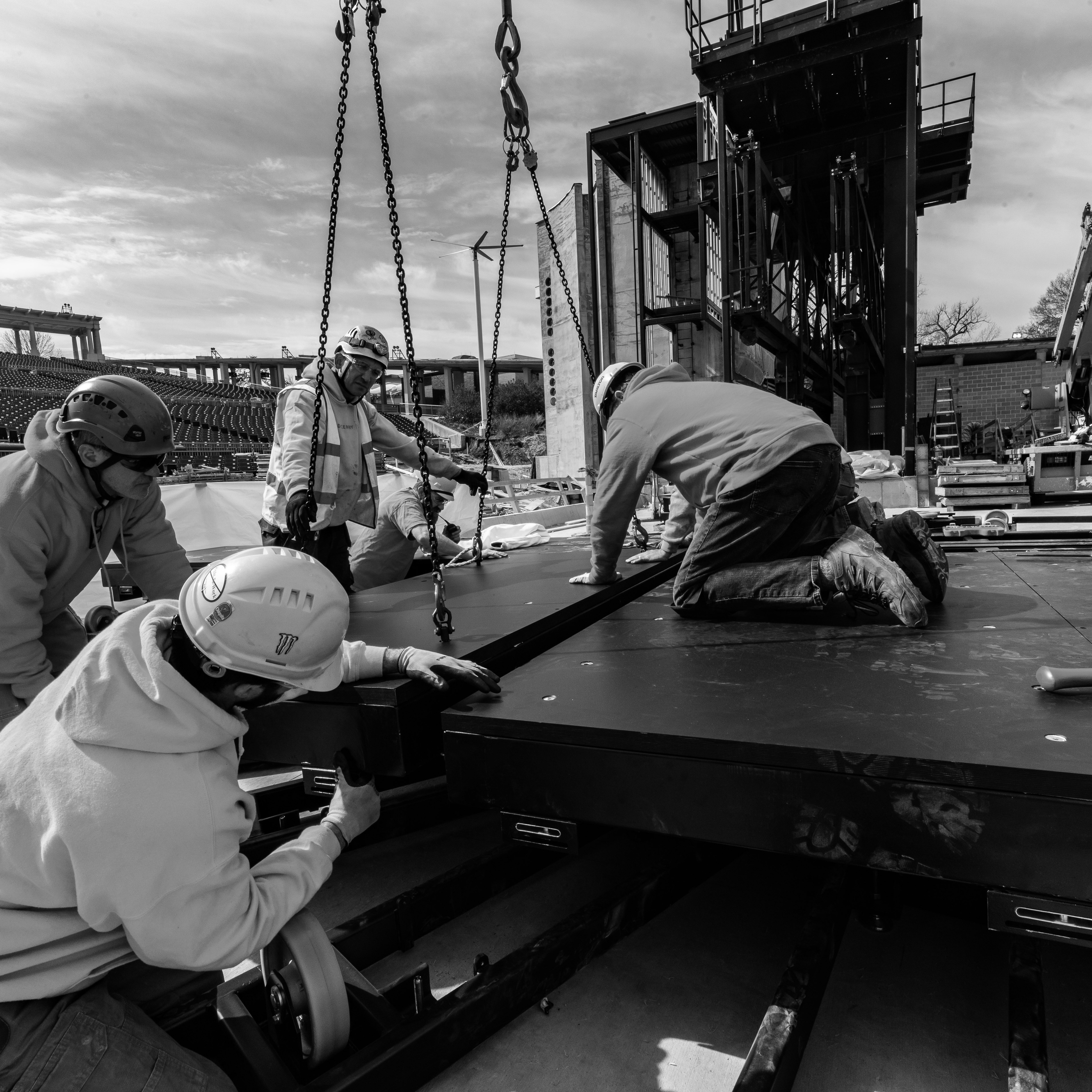 people wearing hardhats working on assembling stage