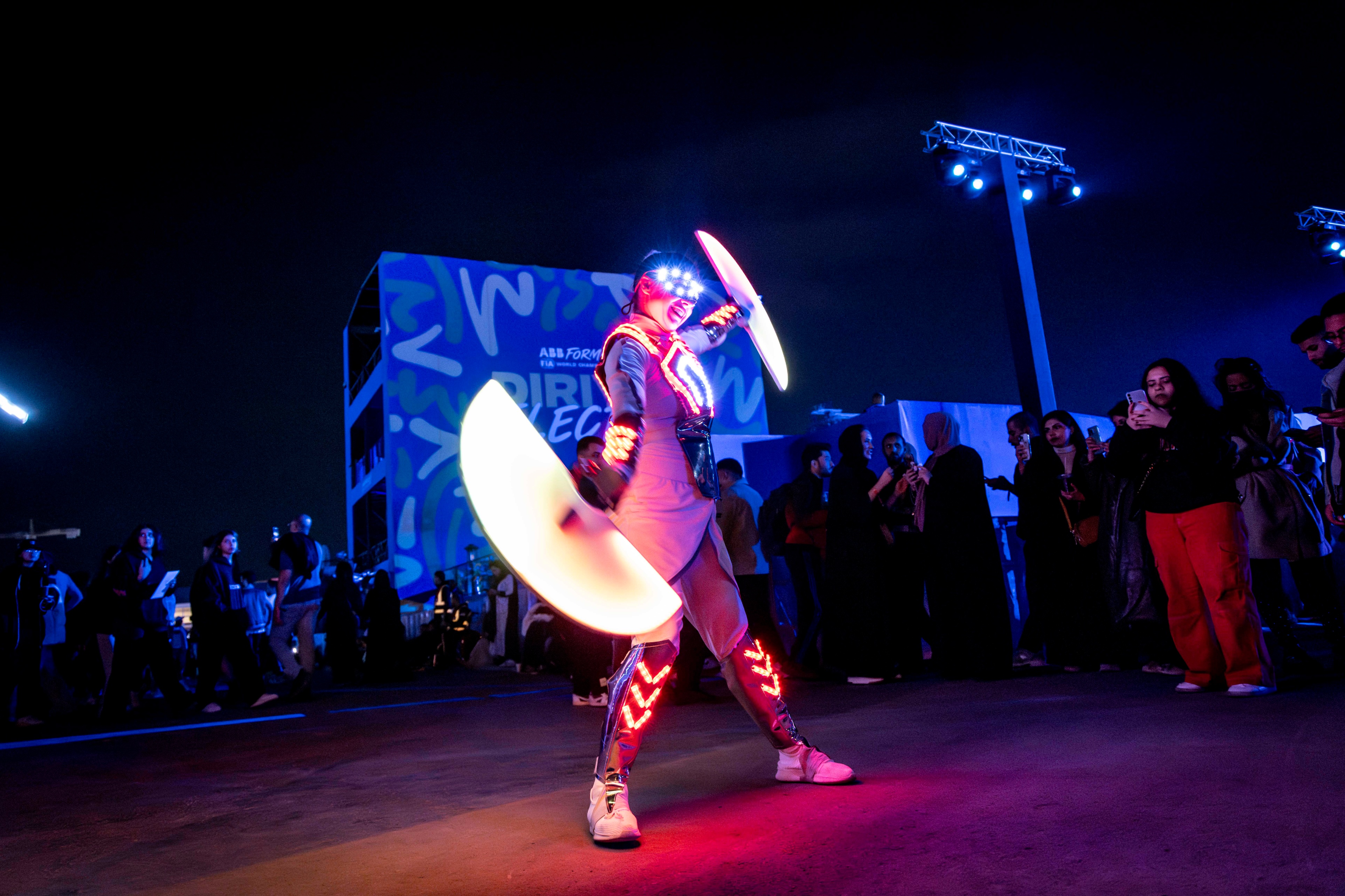 Woman in lit up costume performing in front of crowd 