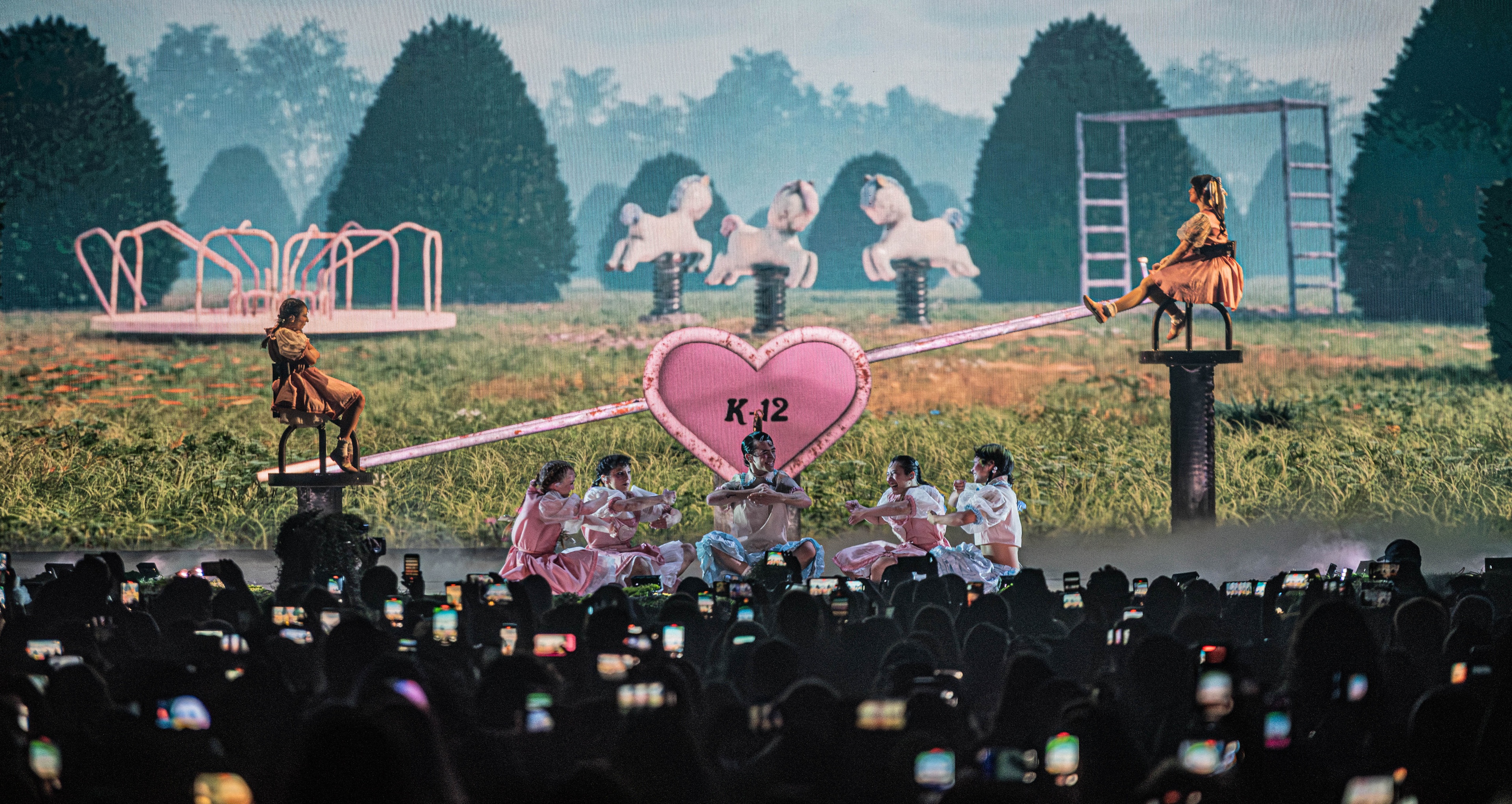 Stage with seesaw and large pink heart in center with K12 on it