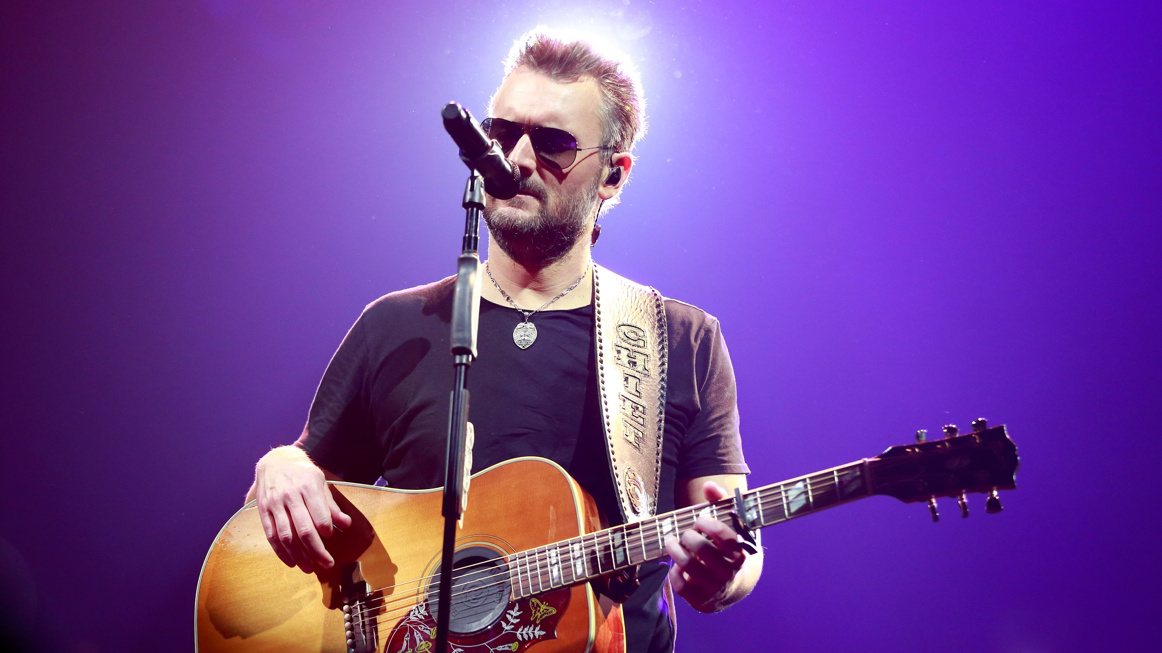 close up of Erich Church singing and playing guitar at the Gather Again Tour