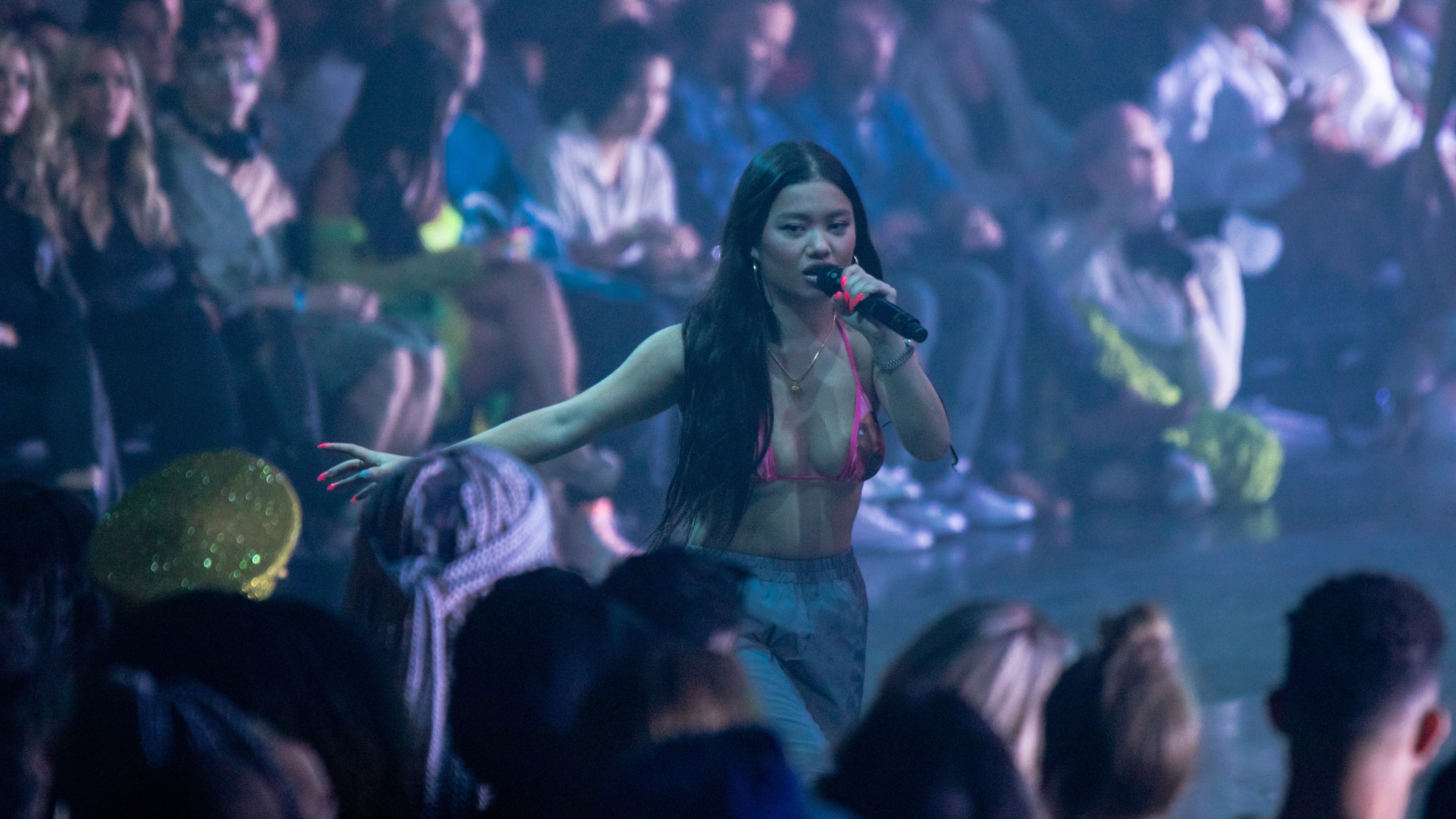 Woman performing in front of large crowd with bikini top