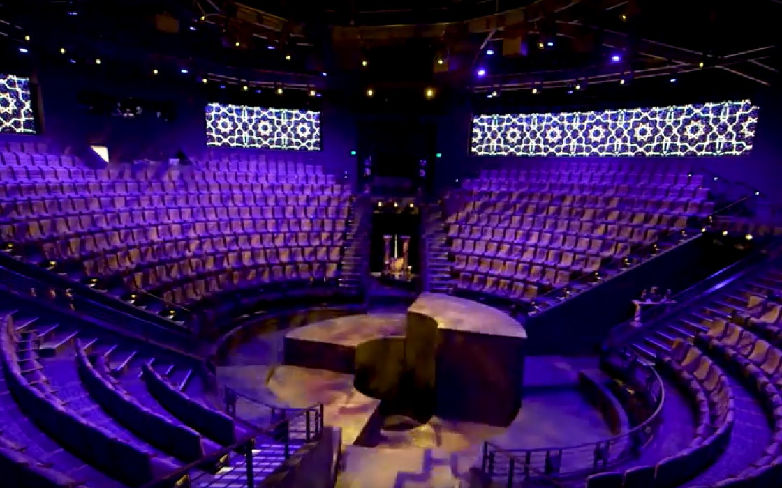 image of stage in center of hale theater with empty seats surrounding