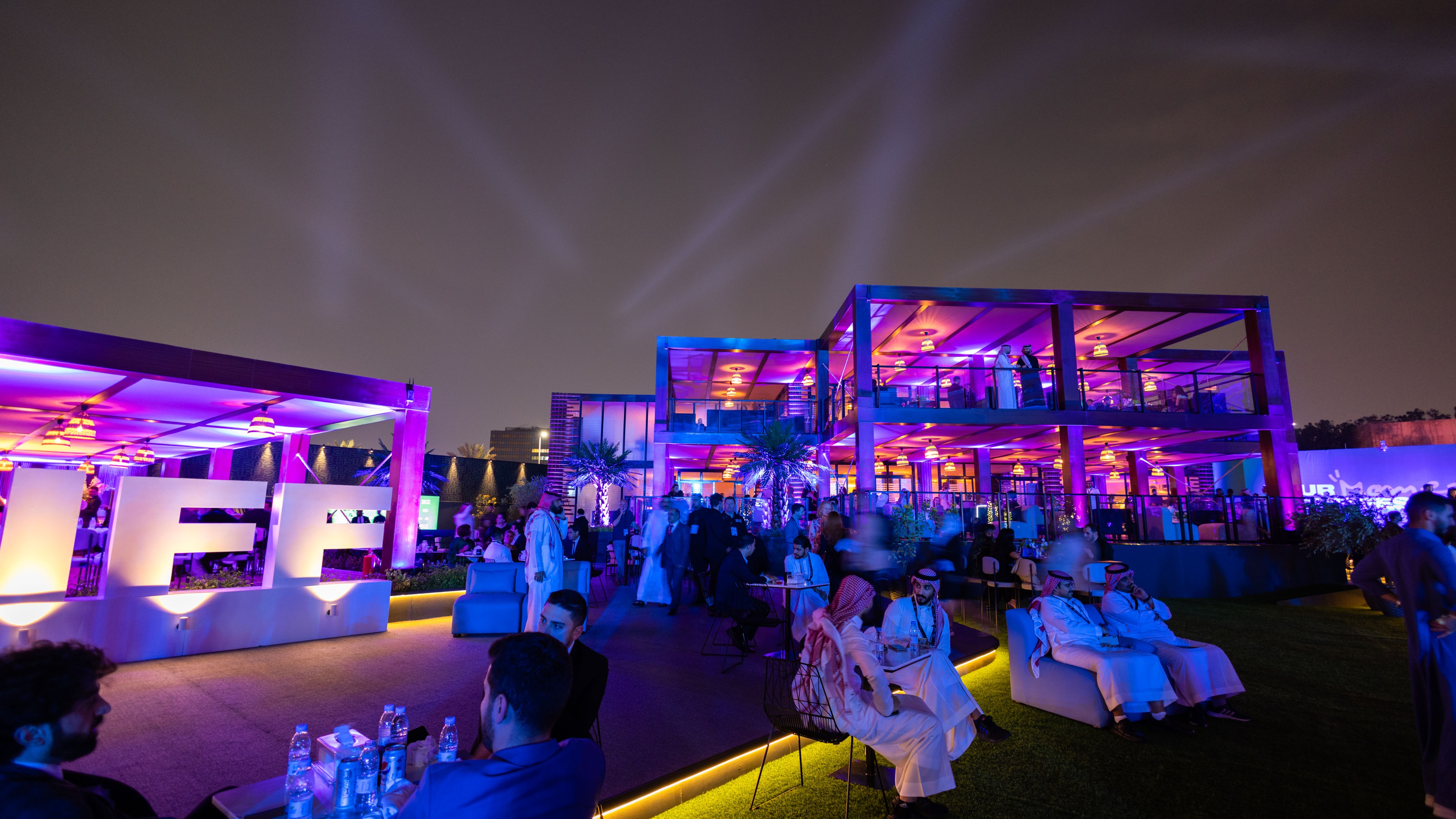 Outdoor guest experience at night with blue and pink lights