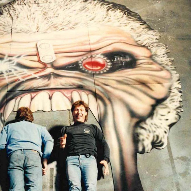 Man in front of monkey mural smiling