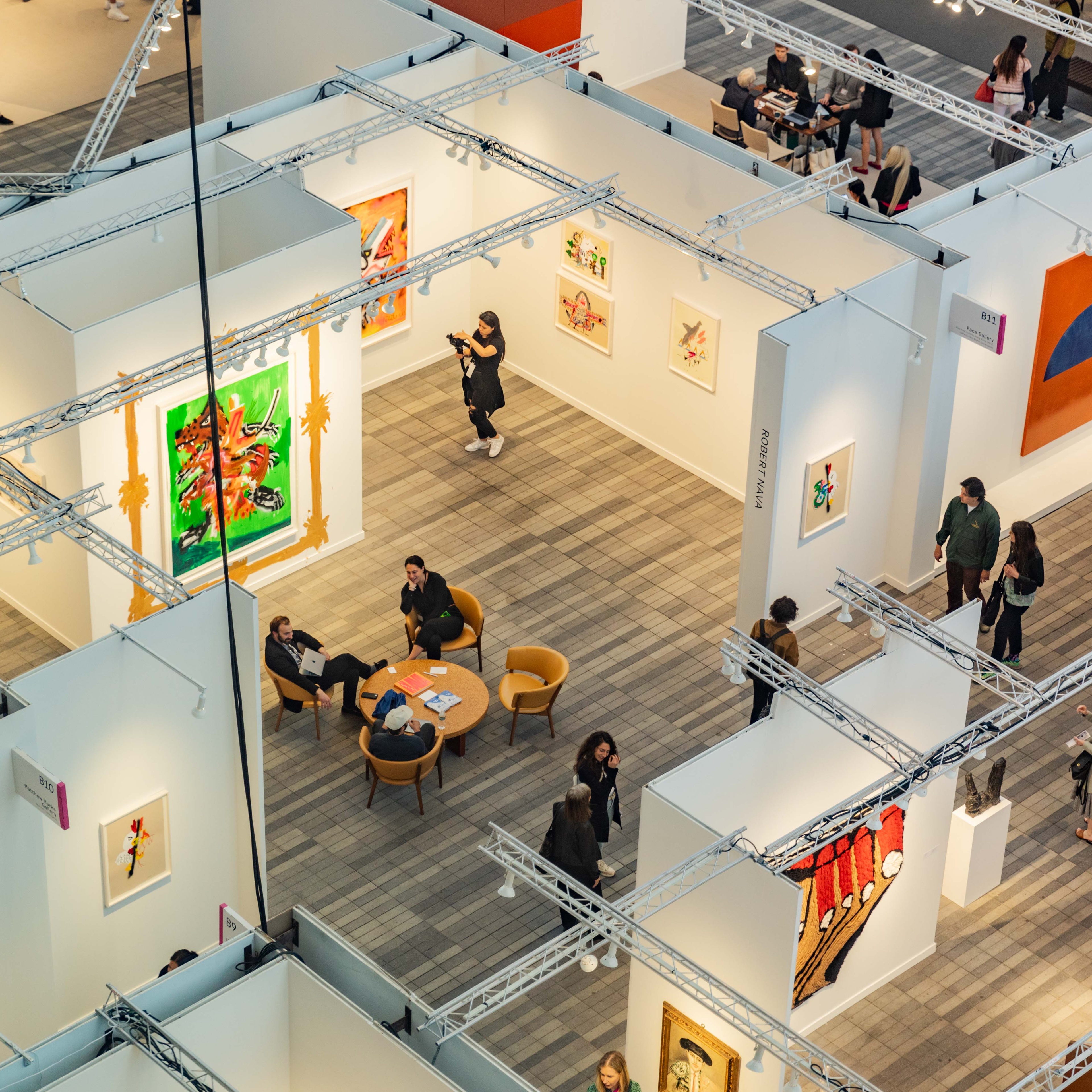 Aerial view of art gallery with three people sitting around a brown table