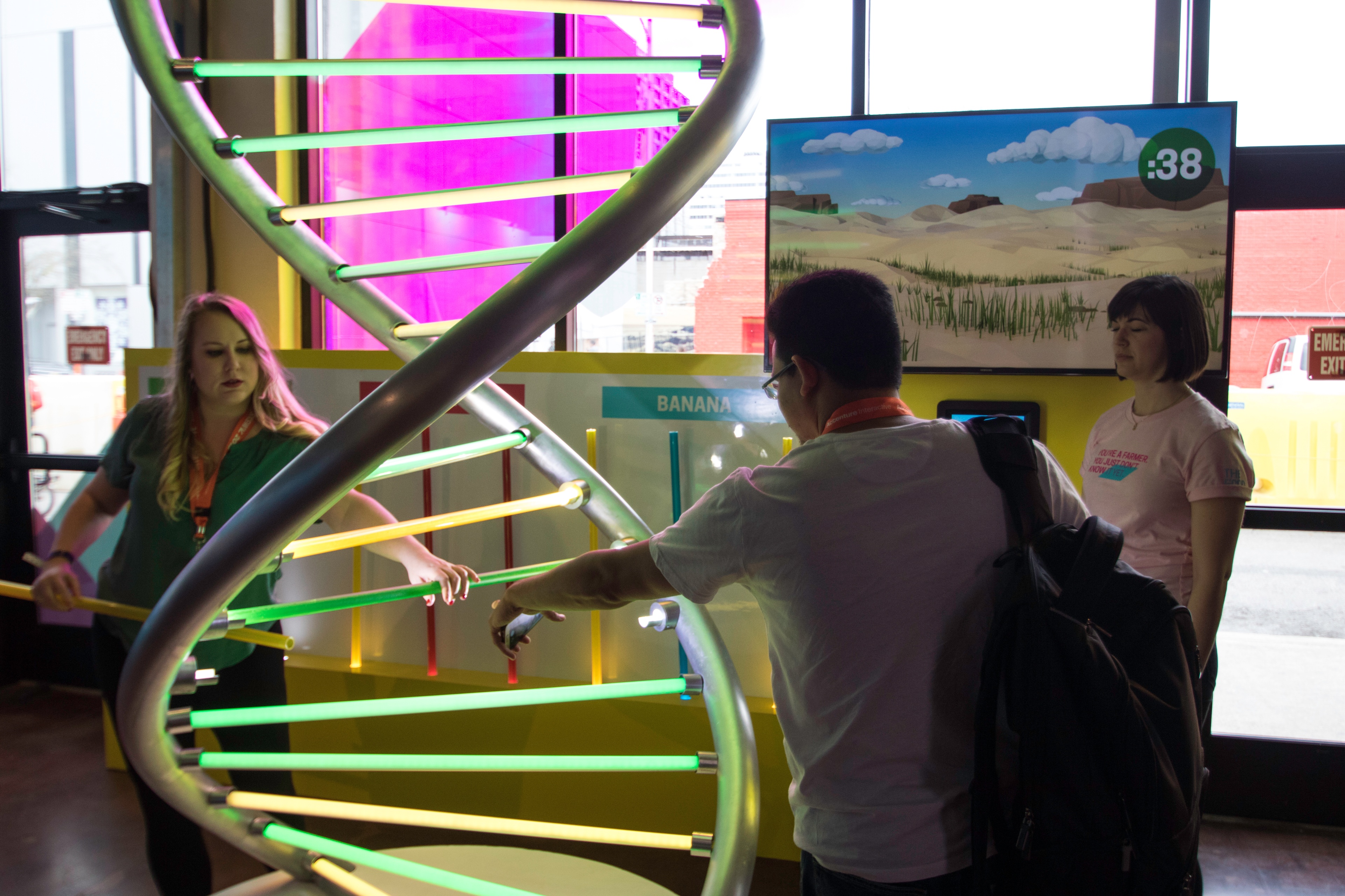 People interacting with a DNA thread sculpture at the Land O’Lakes The Food Effect SXSW event