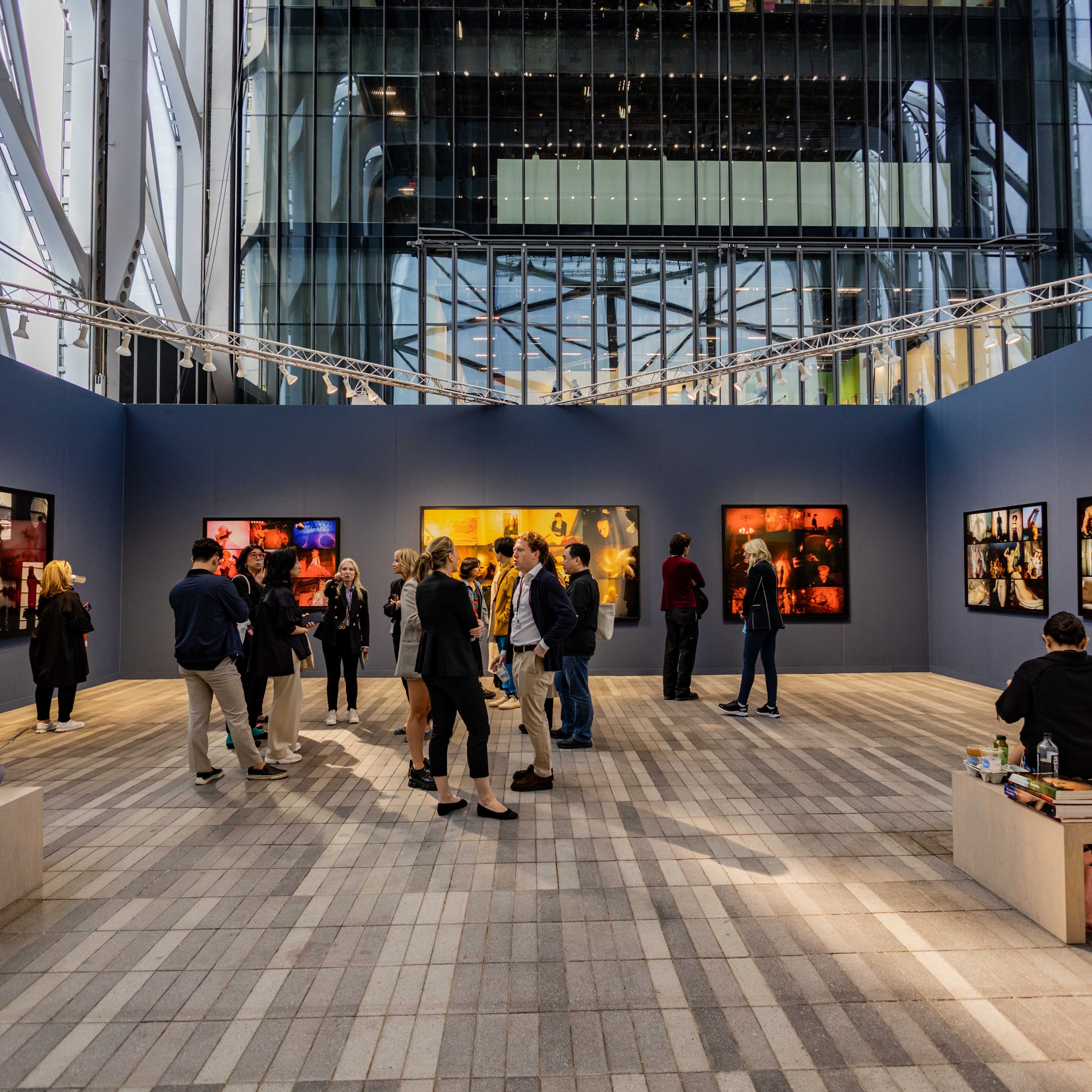 Group of people looking at art that is hanging on a dark blue wall