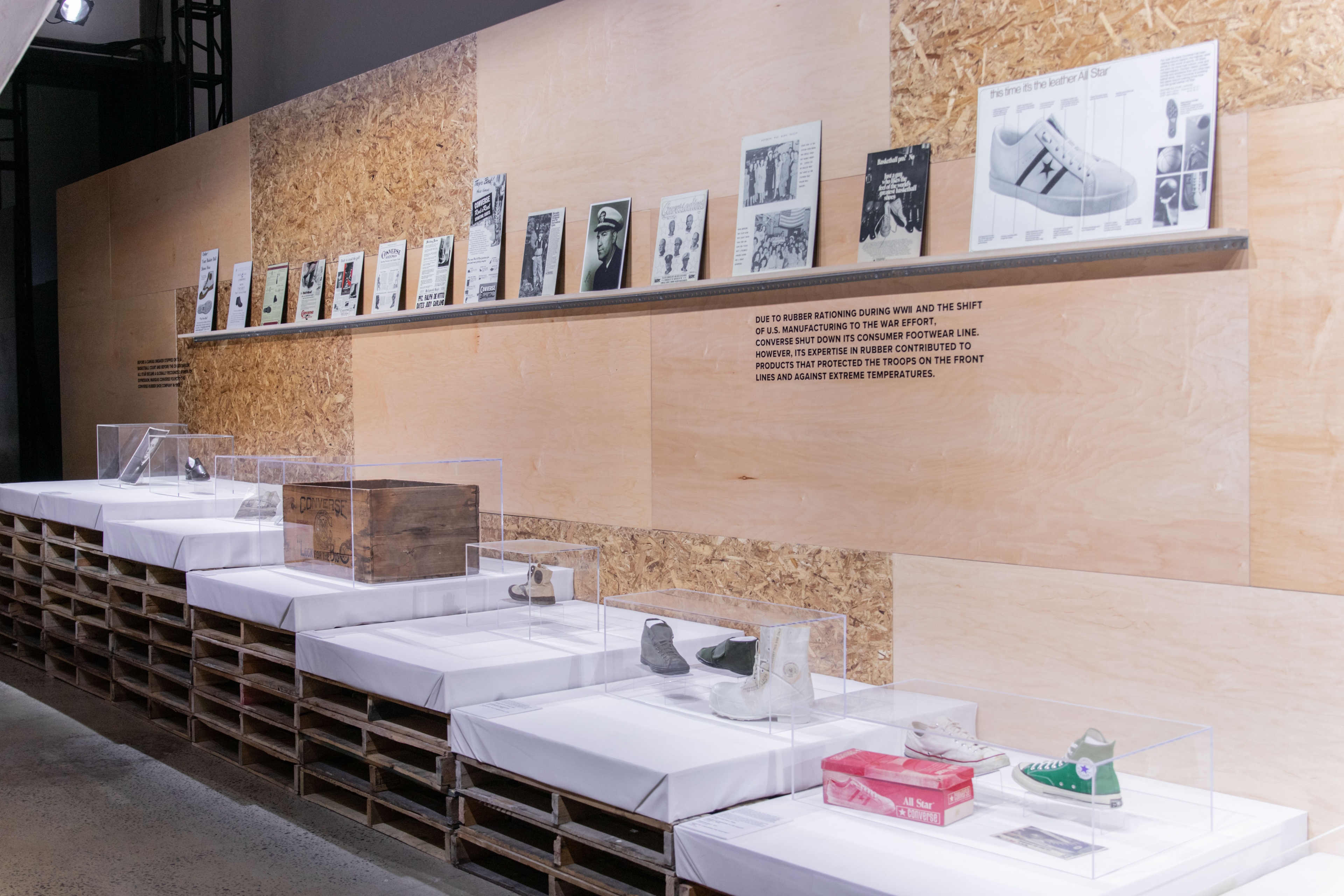 Wooden wall with books showcased on top and shoes on the bottom