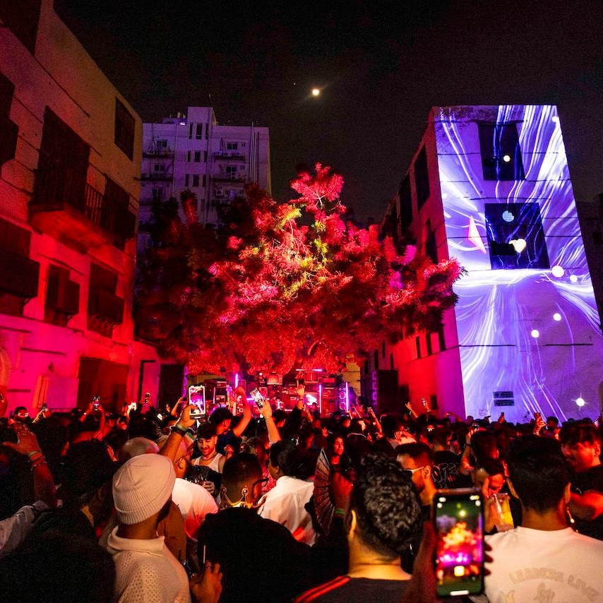 Crowd looking at a stage and buildings with projection mapping