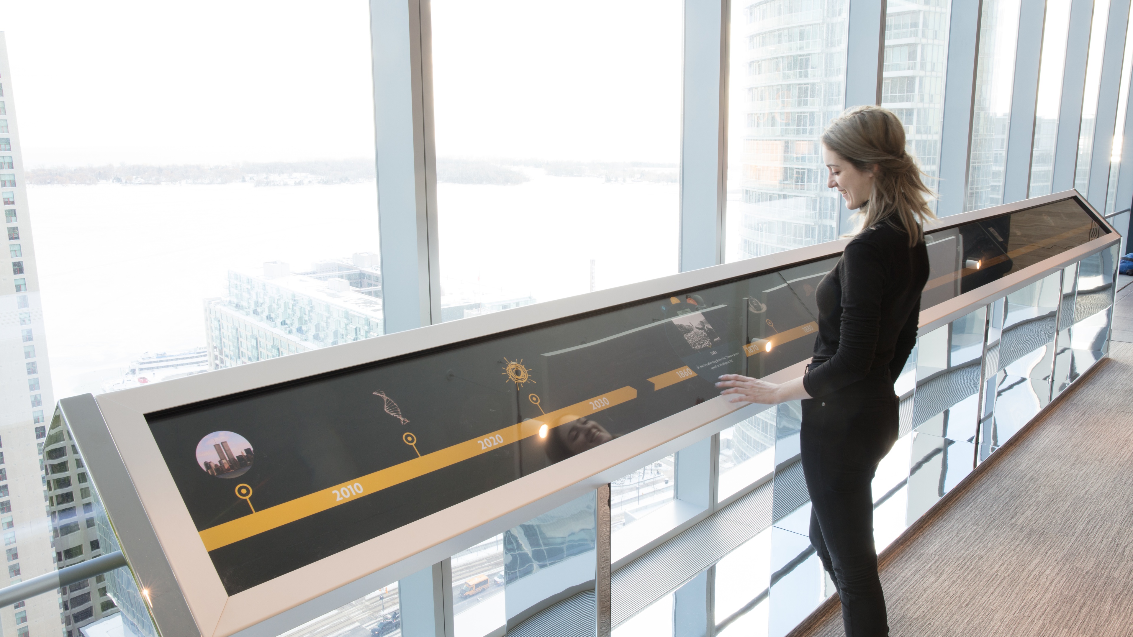 Woman interacting with LED screen showing timeline