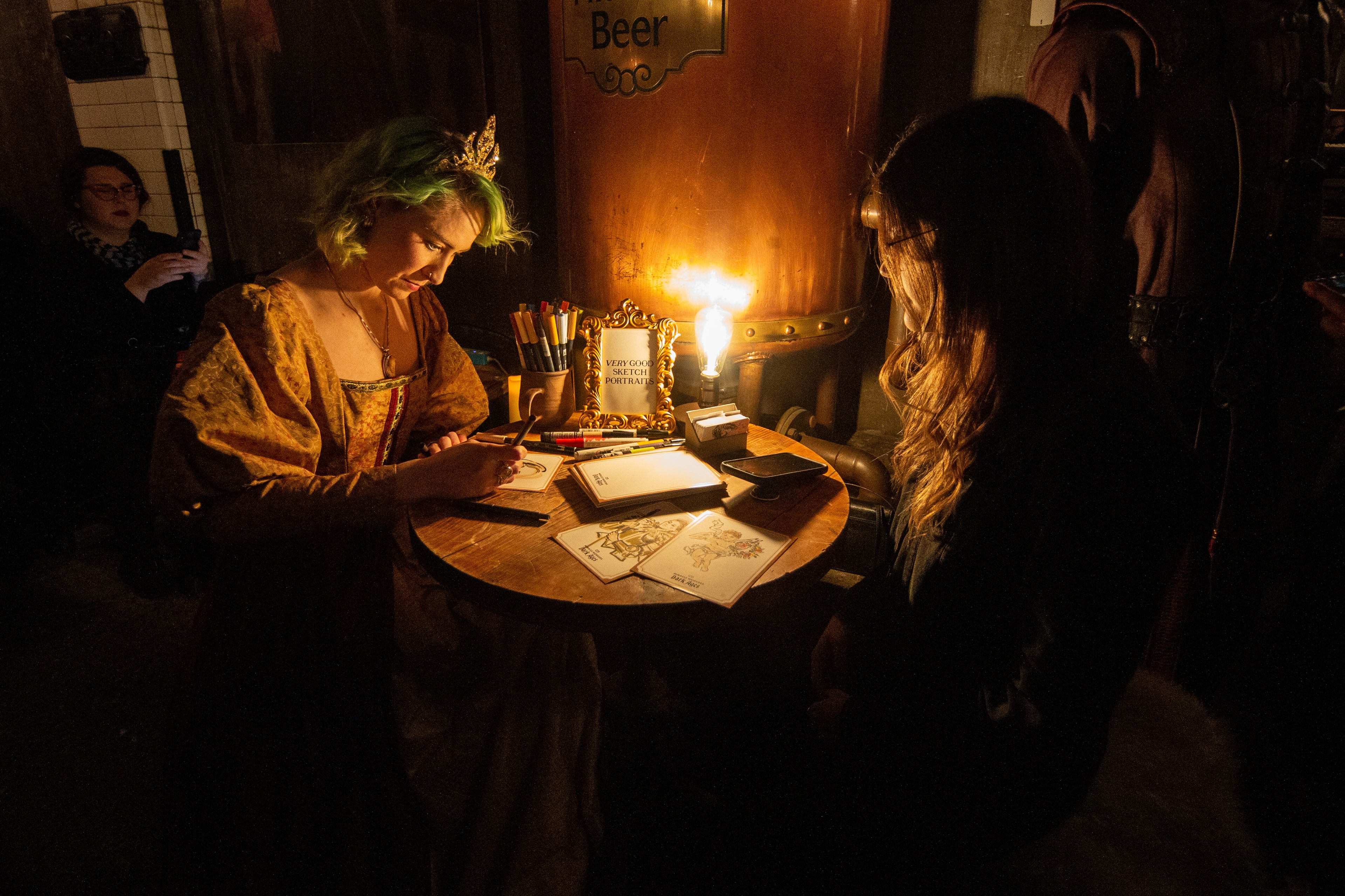 Two women at craft station in dimly lit room