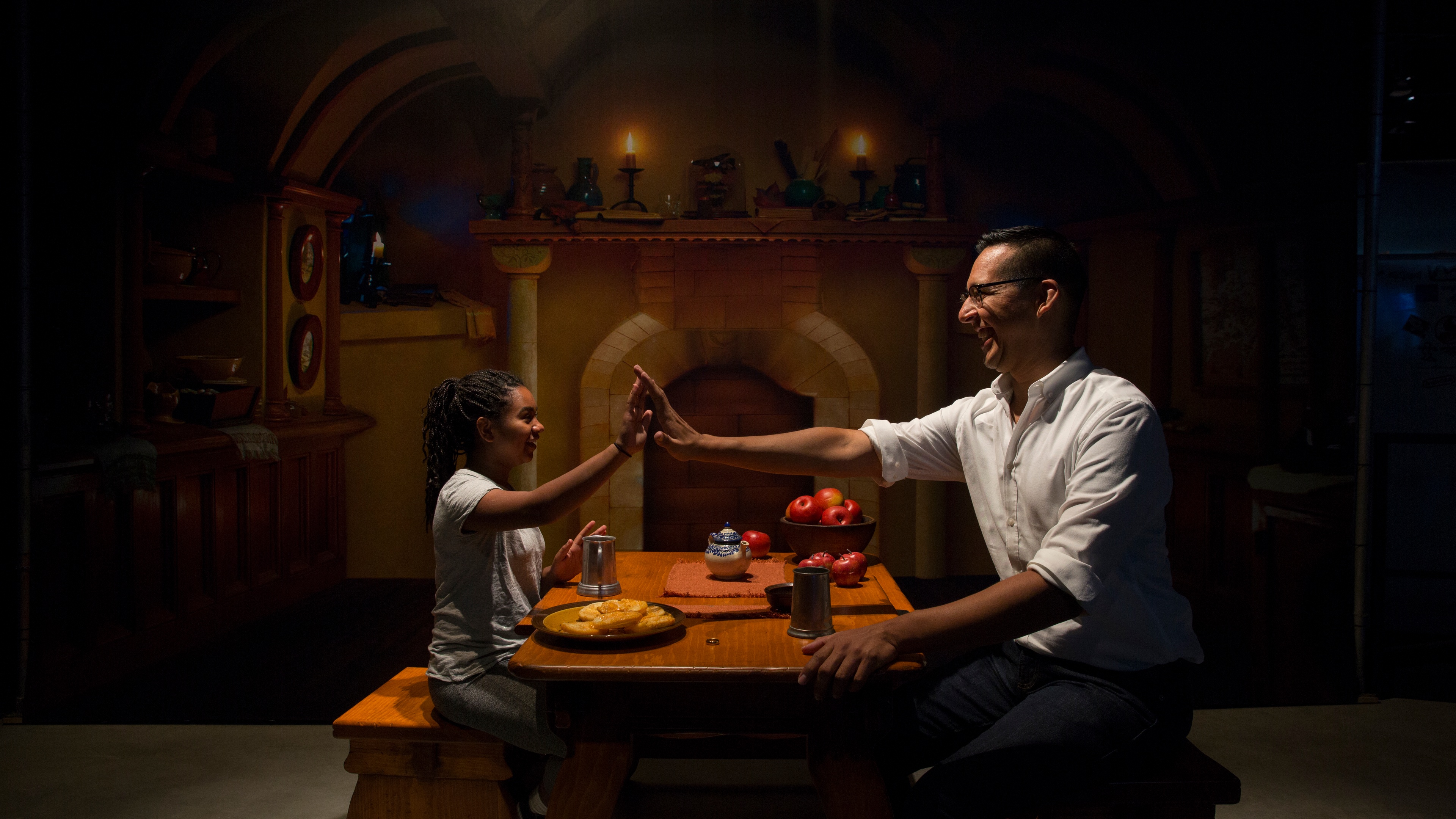 Man and child high fiving at mock dinner table