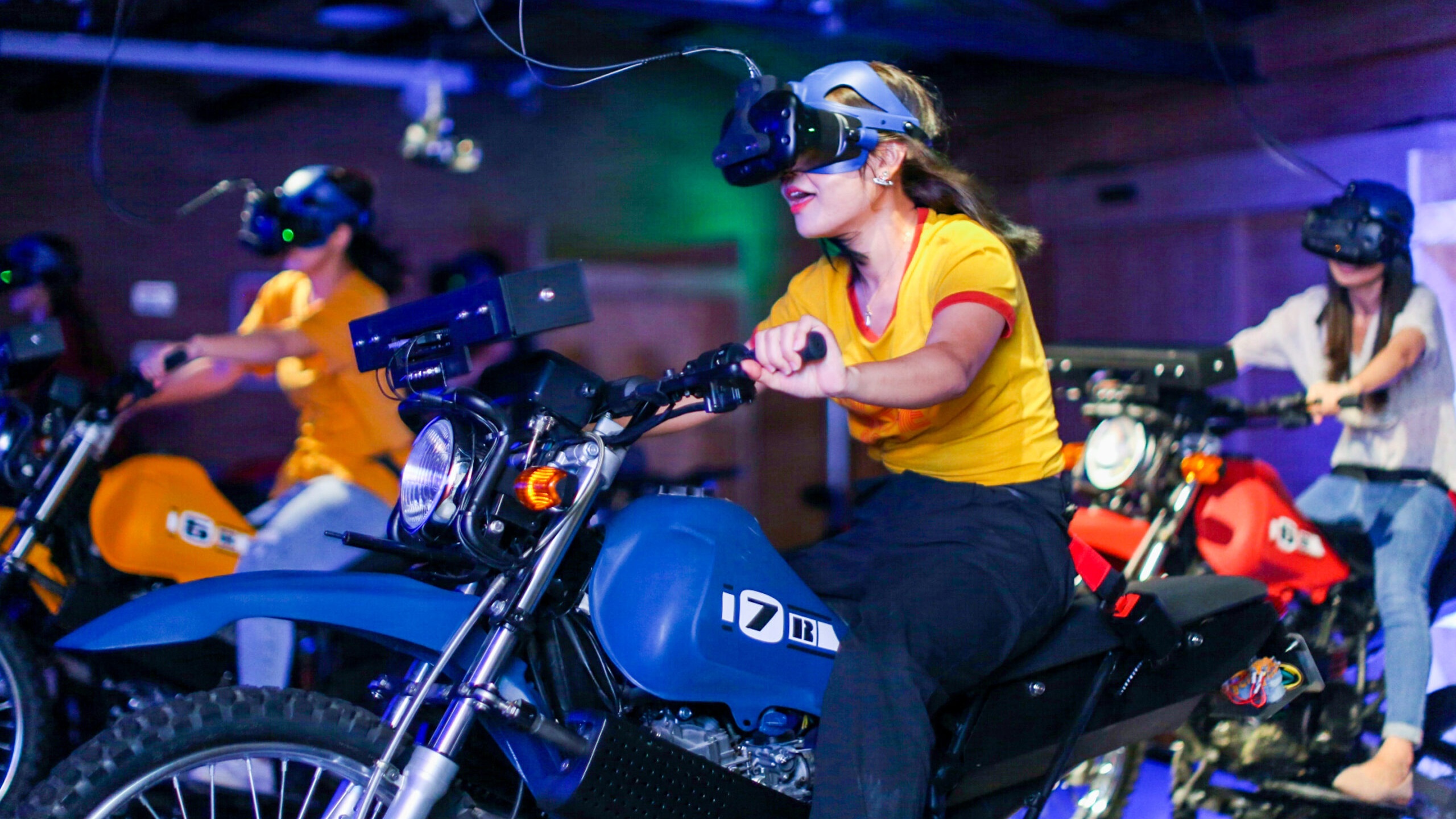 Girl in yellow t shirt riding a motorbike as part of a VR immersive experience