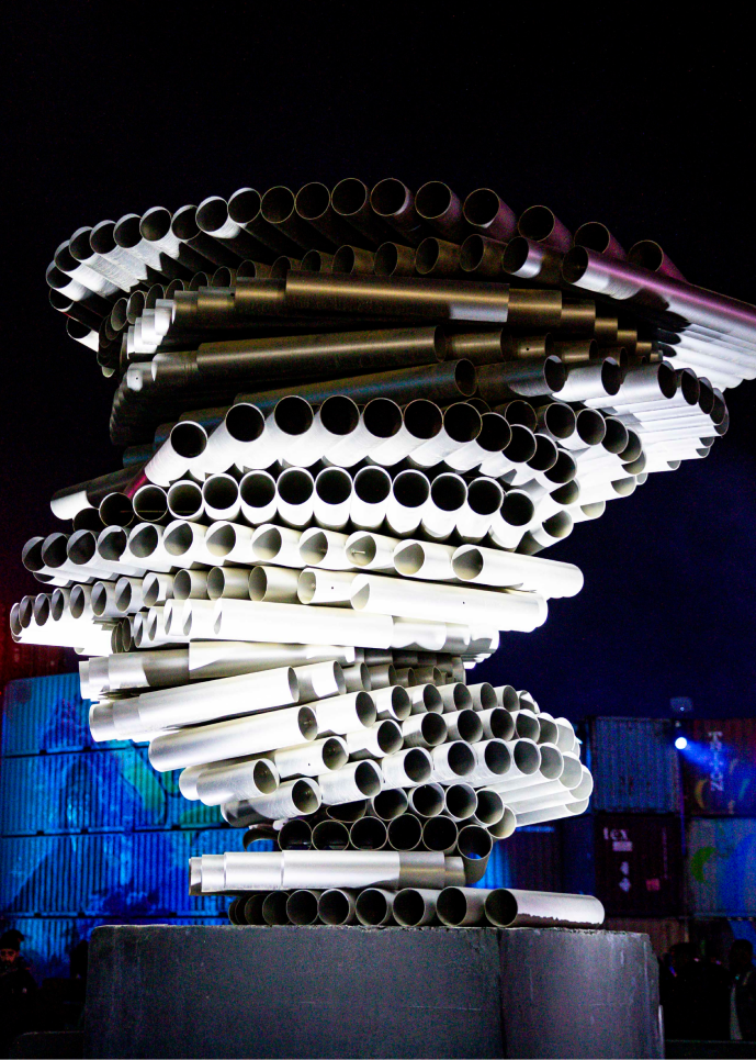 sculpture of large metal pipes stacked in the form of a tornado
