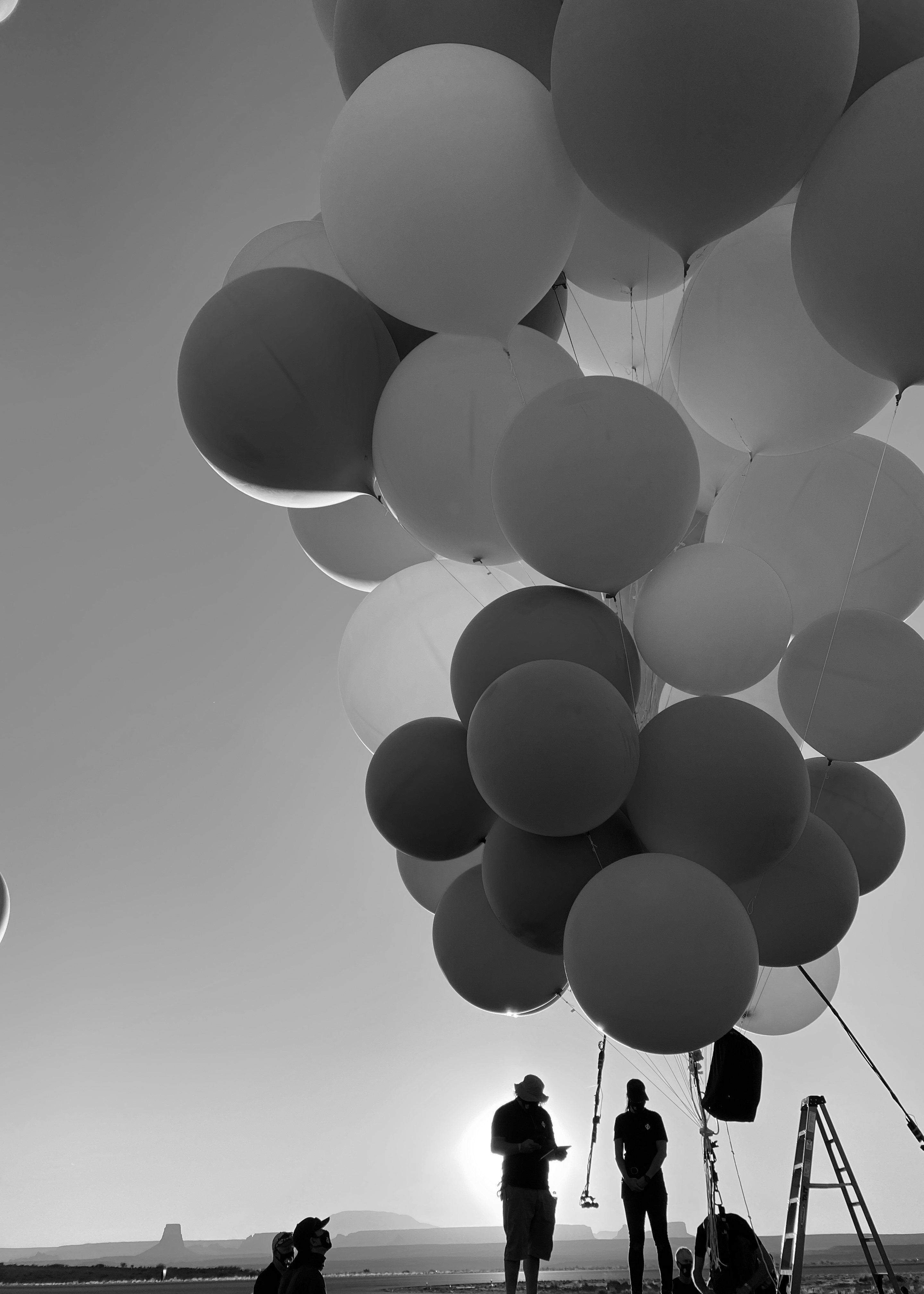 people standing holding giant balloons