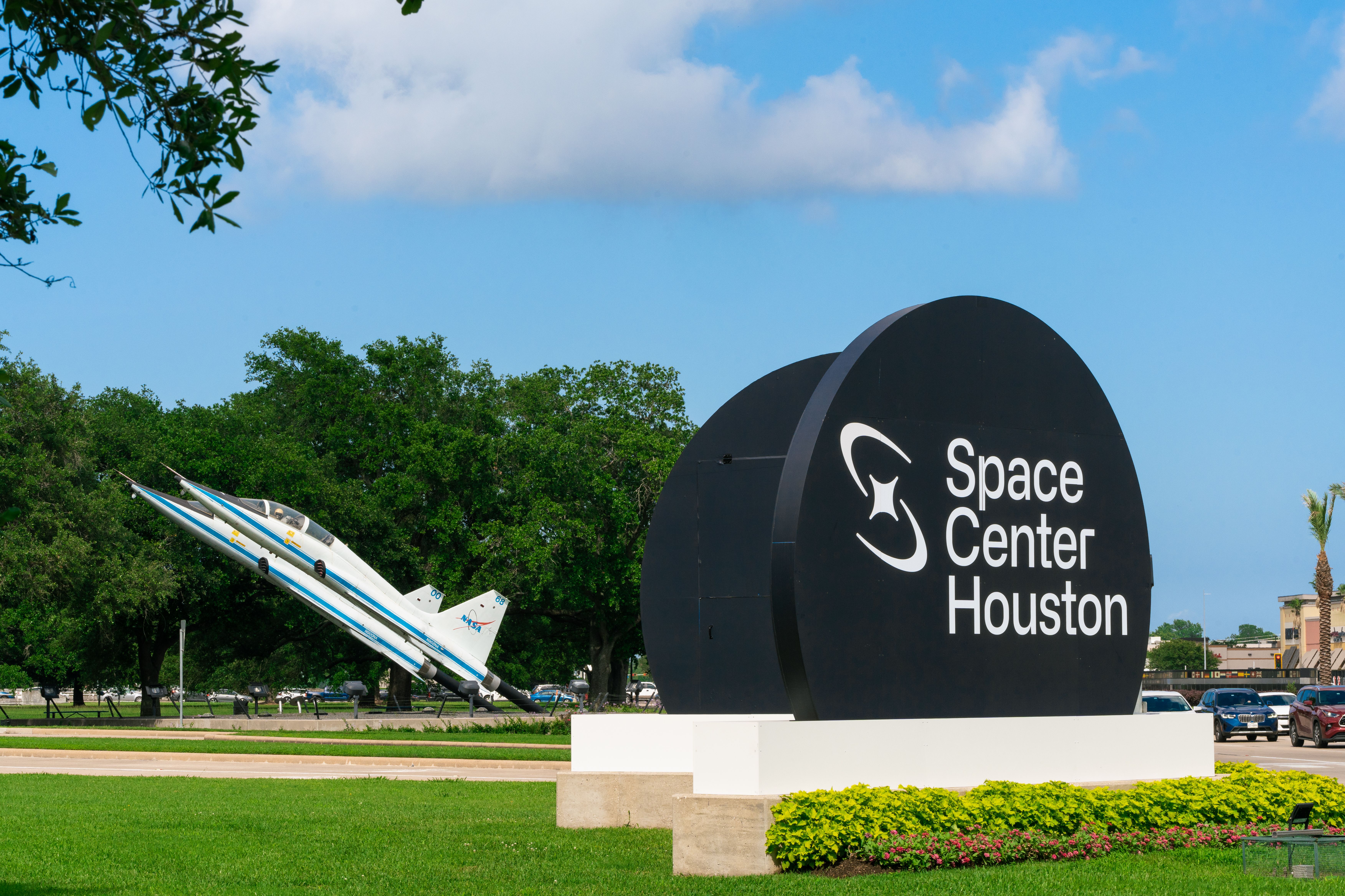 Space Center Houston round black sign outside with ship in back