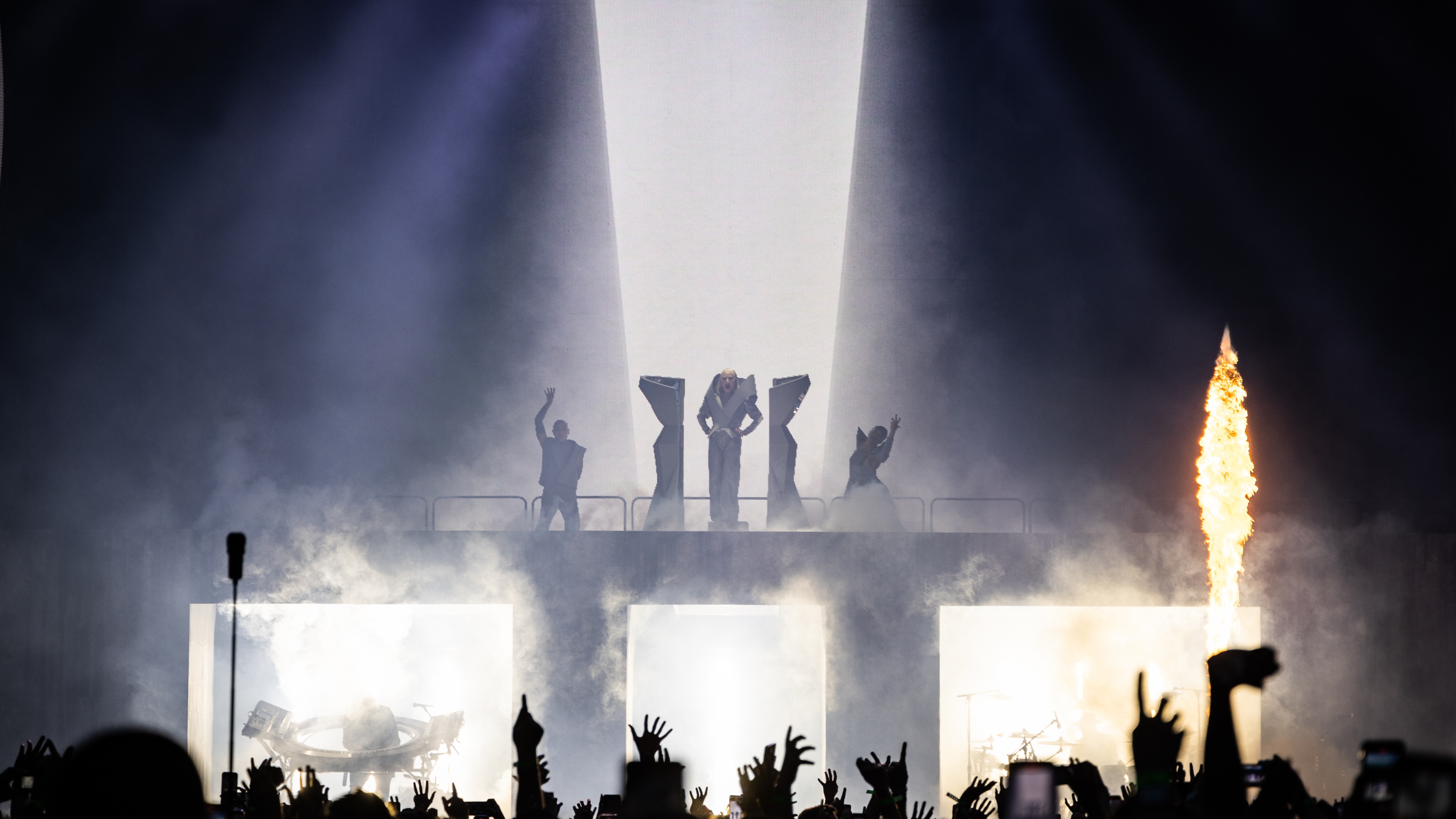 Singer Lady Gaga stood on podium on stage with cheering crowd stage smoke and pyro effects