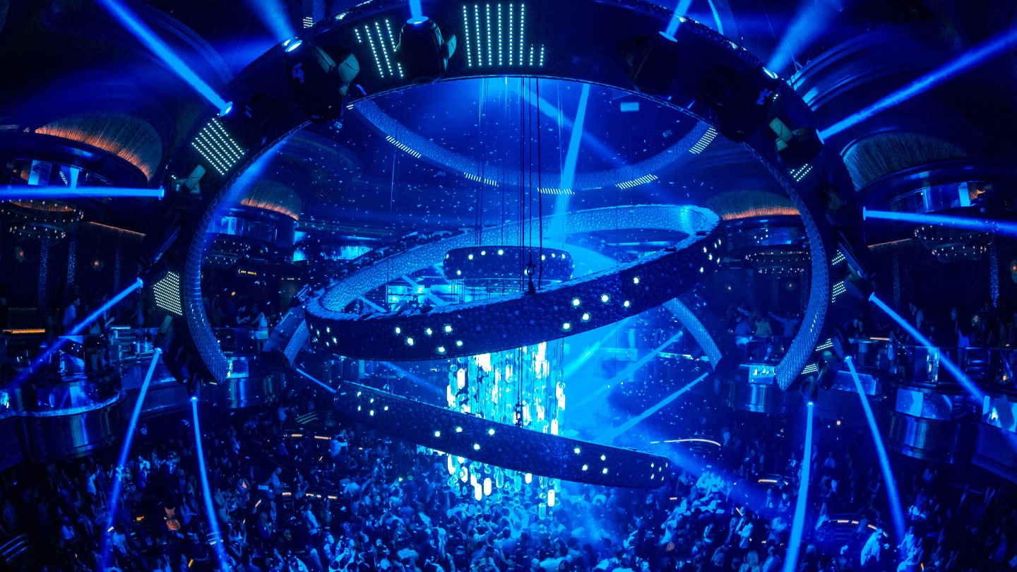 club full of people with chandelier moving around the ceiling
