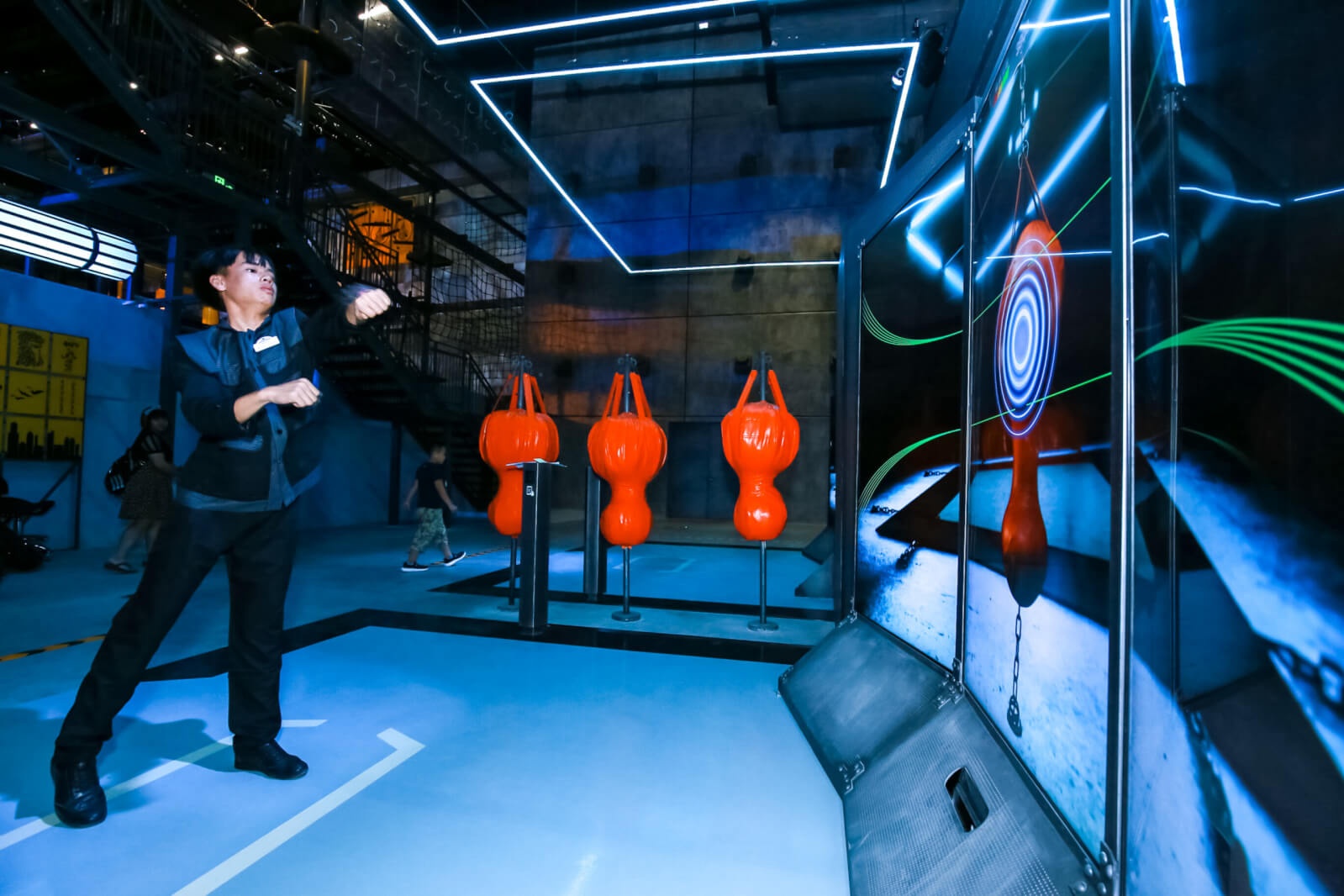 Woman interacting with futuristic VR Boxing game surrounded by LED lights