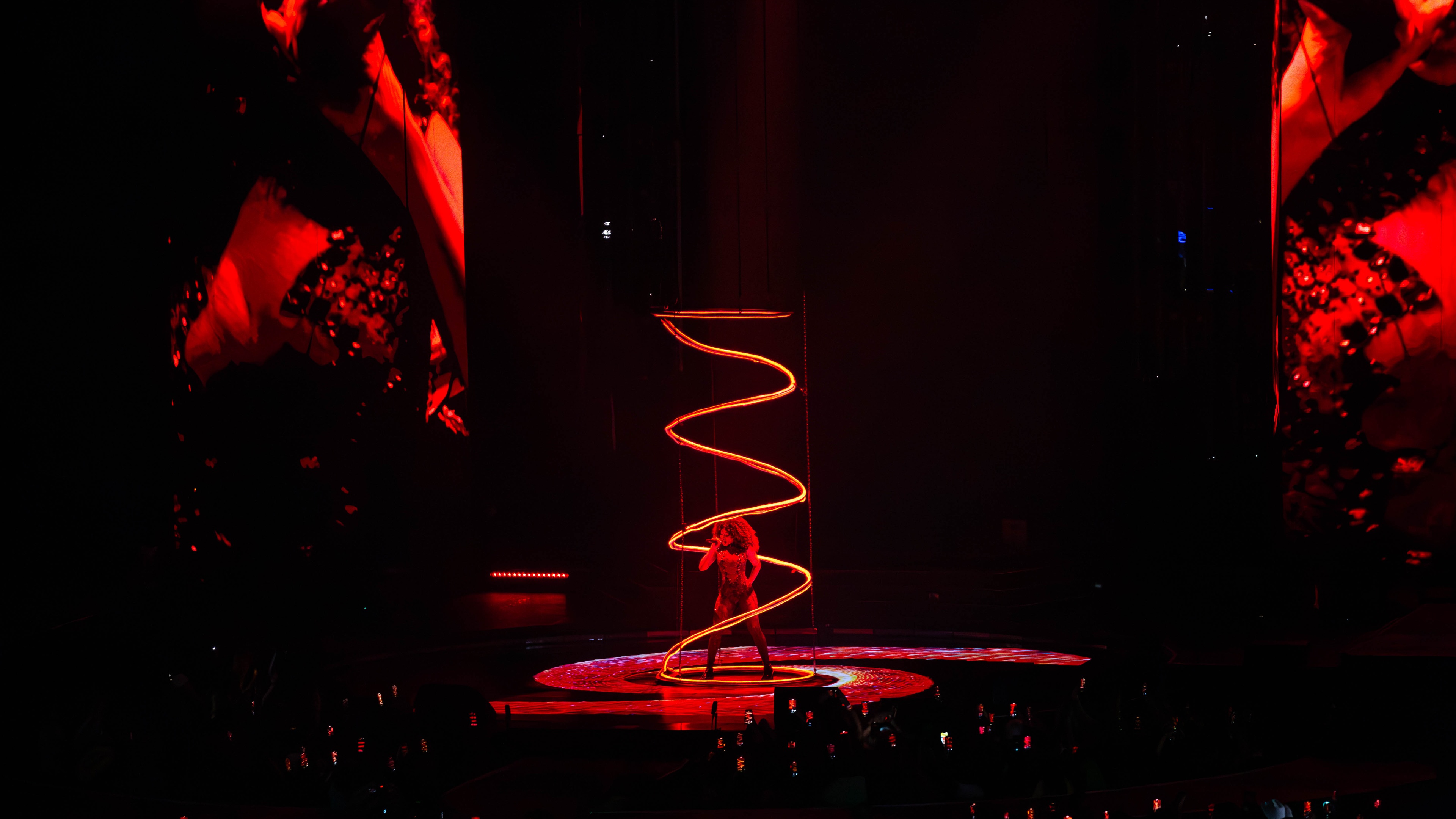 Stage with woman inside LED spiral and red lights
