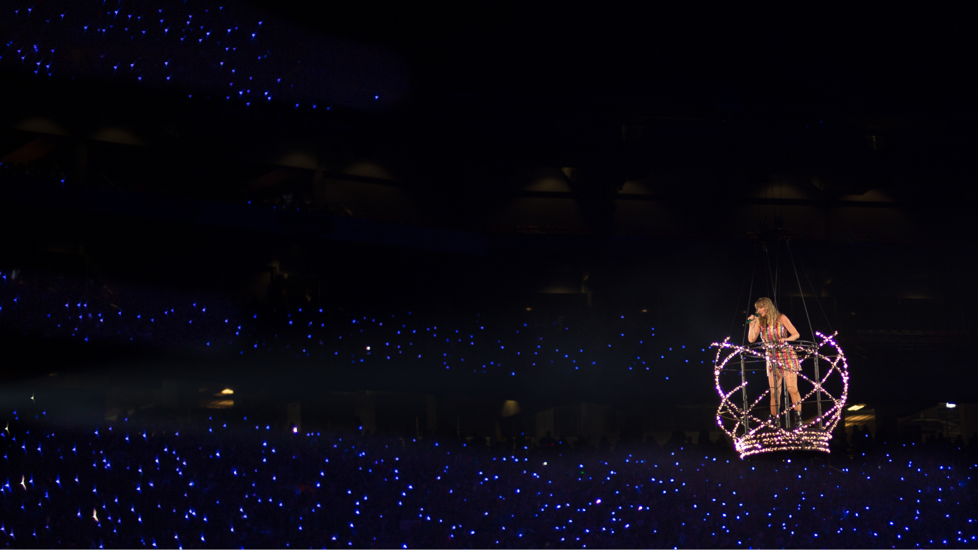 taylor swift performing on a floating stage over audience
