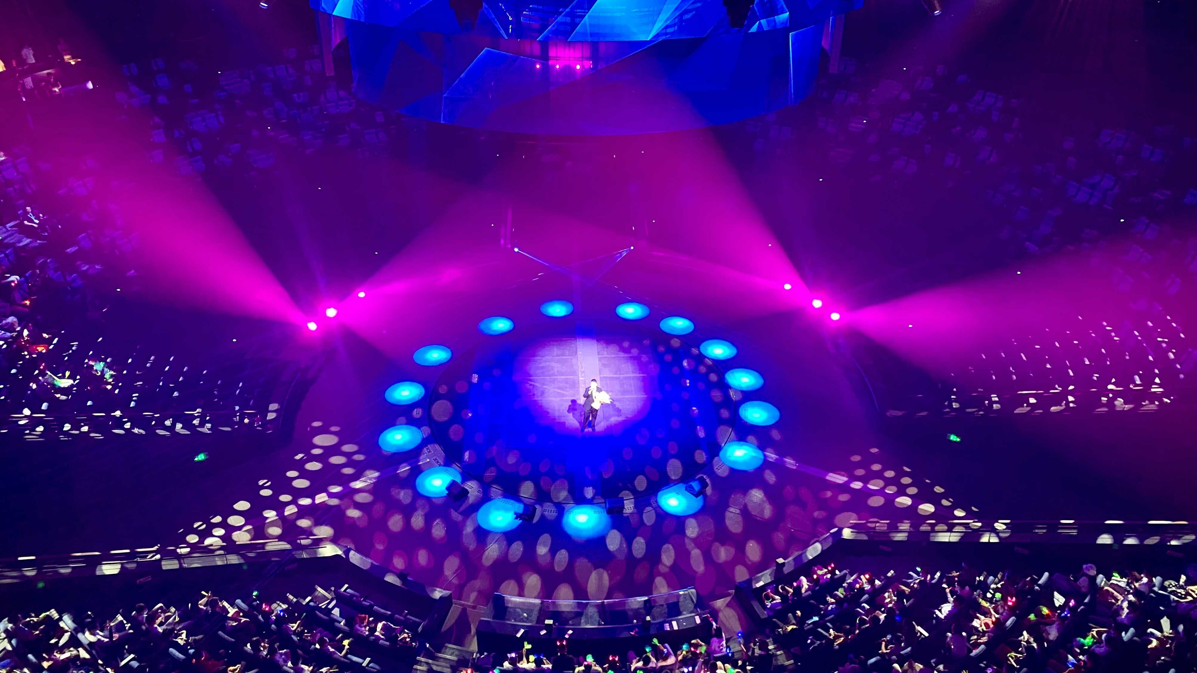 Theatre show in the round with spot lights crowd watching
