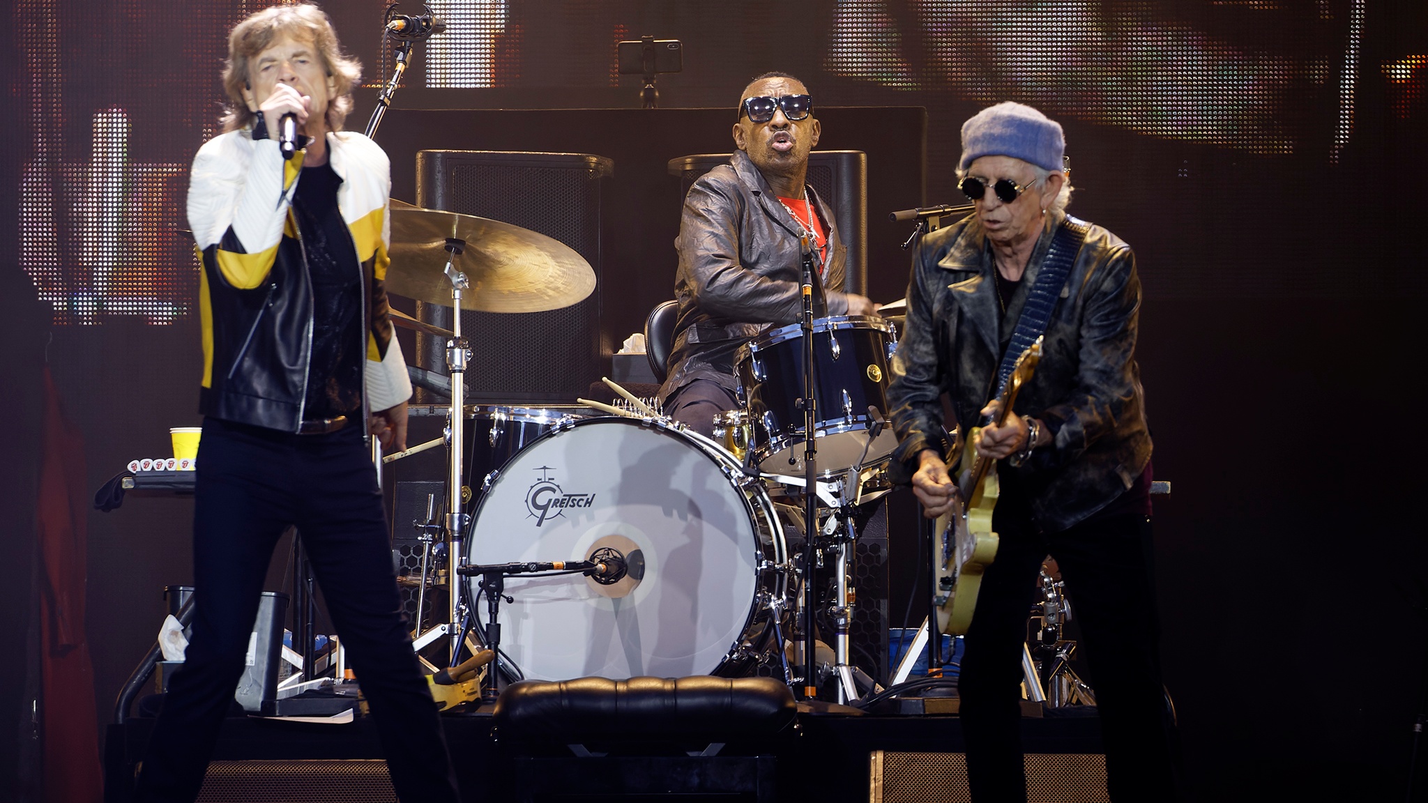 Mick Jagger Keith Richards and Steve Jordan performing live against LED screen
