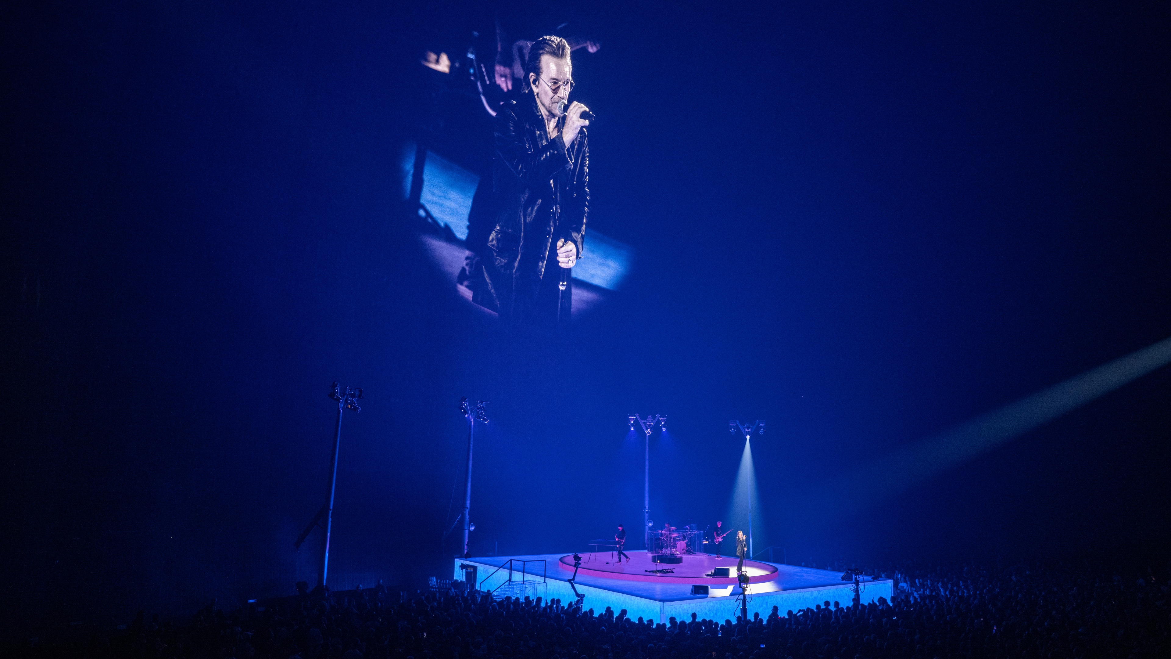 U2 playing on video lit stage in front of video backdrop focusing on lead singer bono at The Sphere in Las Vegas