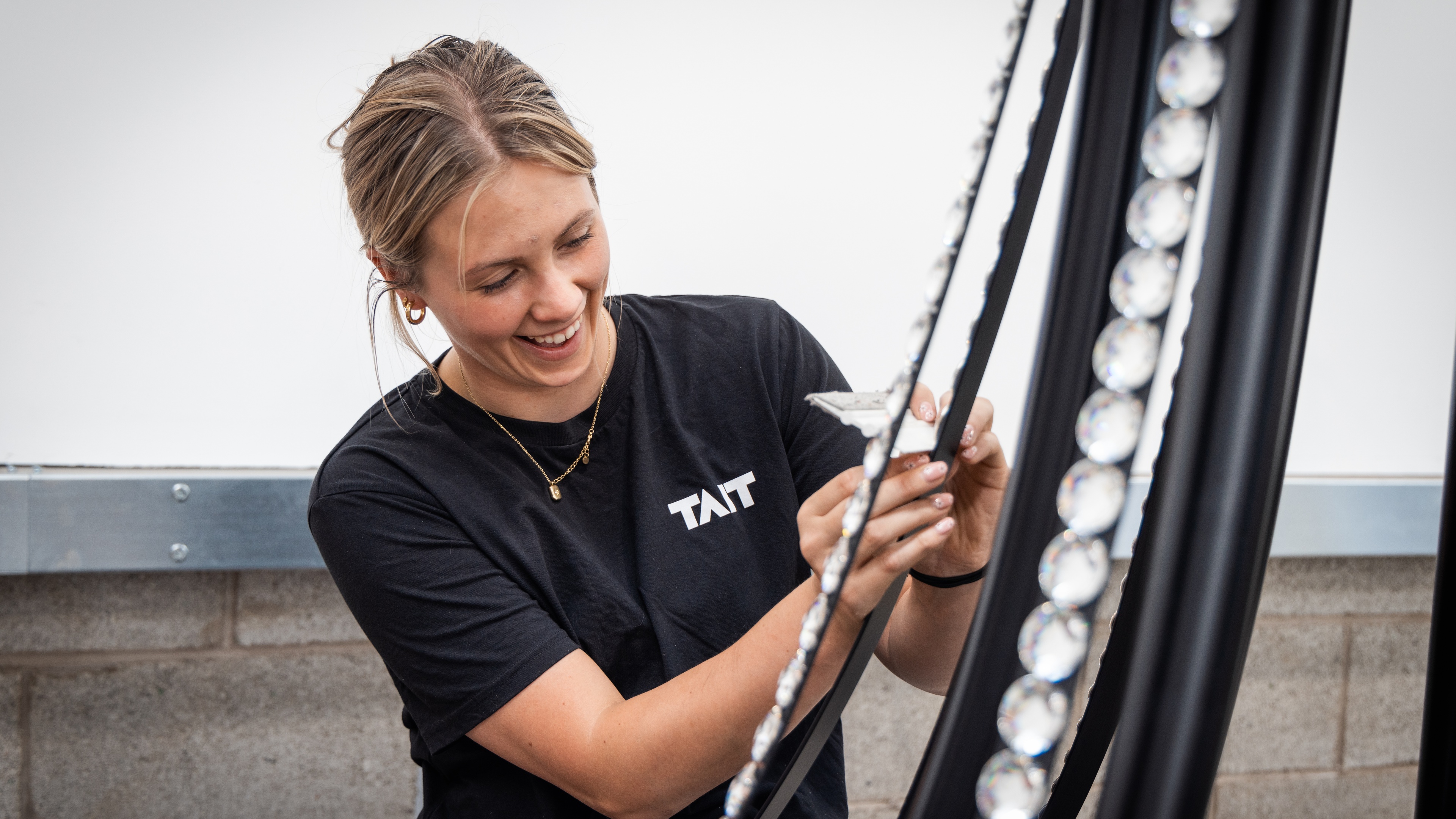 Female TAIT team member applying Swarovski crystals to chandelier