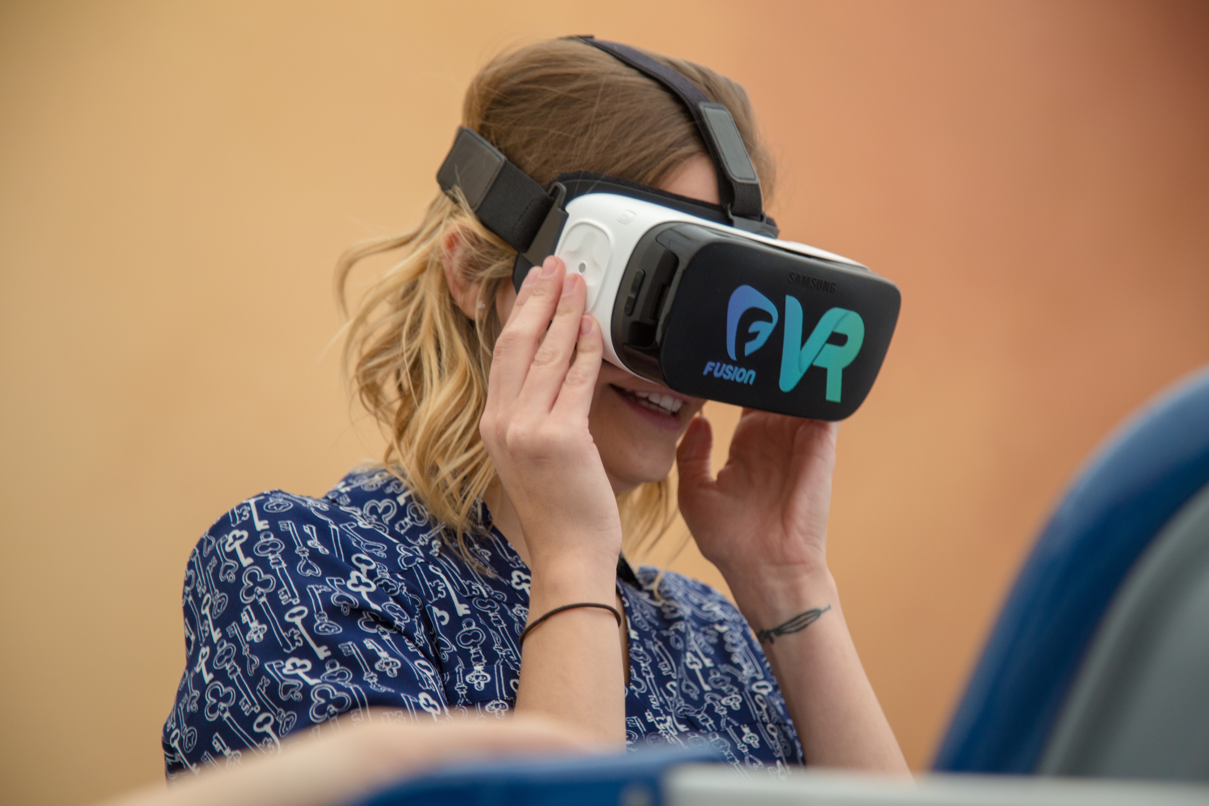 Blonde woman wearing VR headset and smiling