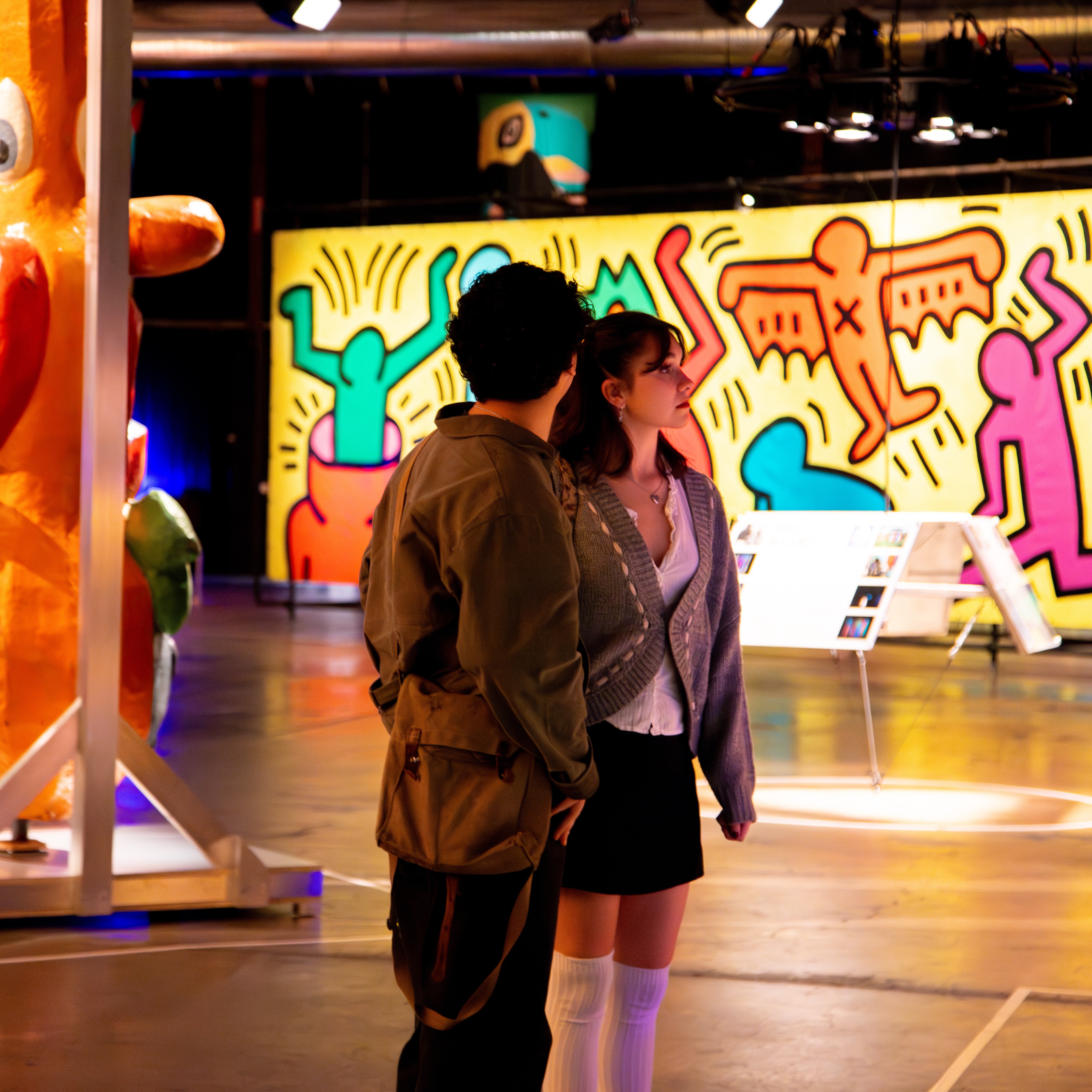 Luna Luna Forgotten Fantasy male and female surrounded by Keith Haring mural and carousel, and Kenny Scharf art