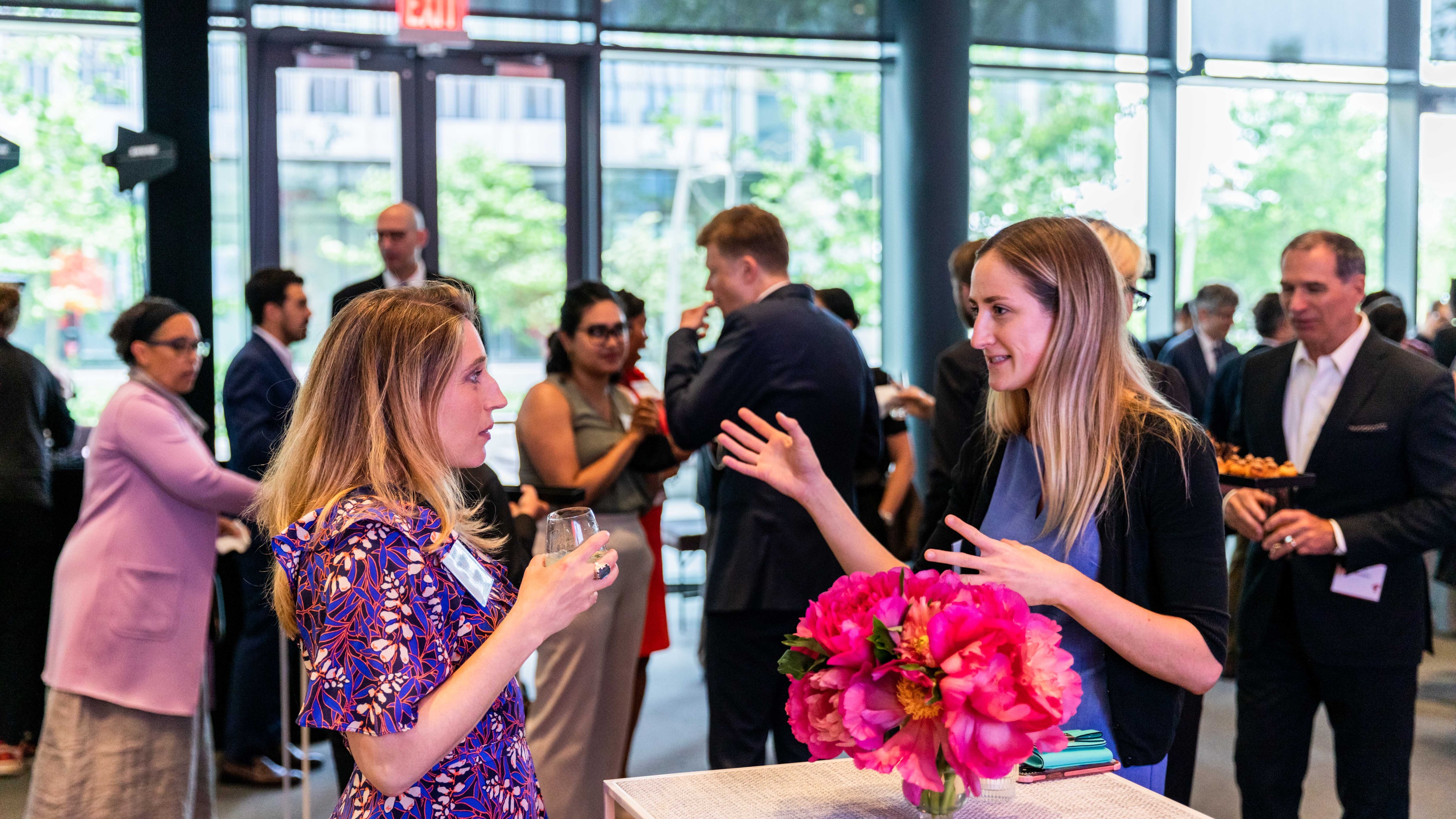 Two blonde women chatting at high top table during Cornell University celebration