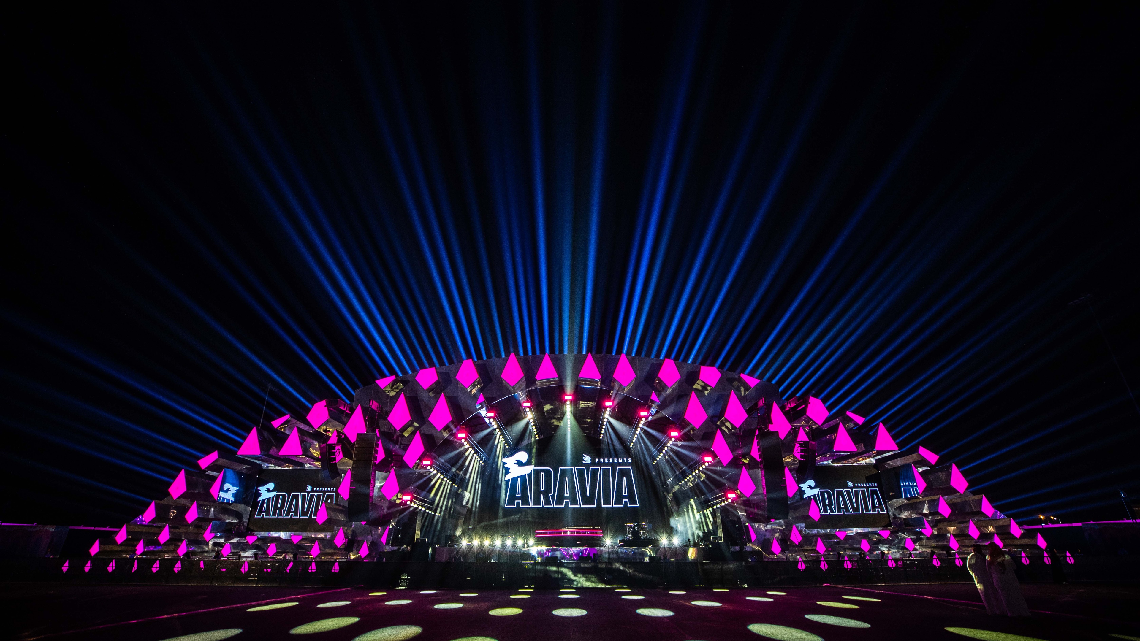 Night time view of Aravia MDLBEAST event's stage lit up in pink and blue lights