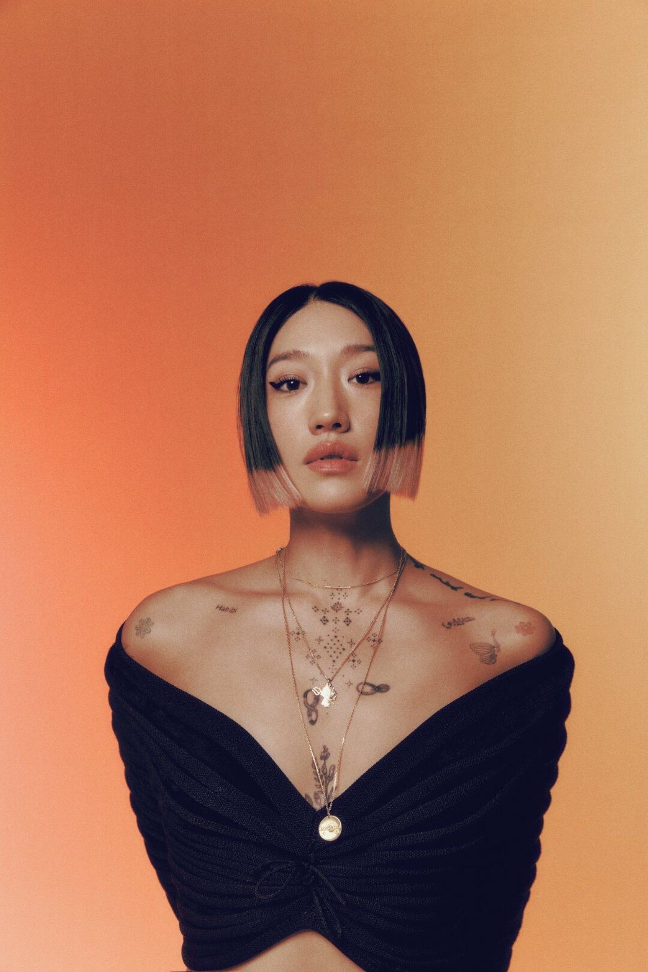 Artist, Peggy Gou, photographed in front of an orange backdrop