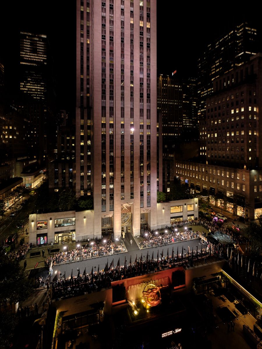 Night runway show at Rockefeller Center with the tower lit above the crowd