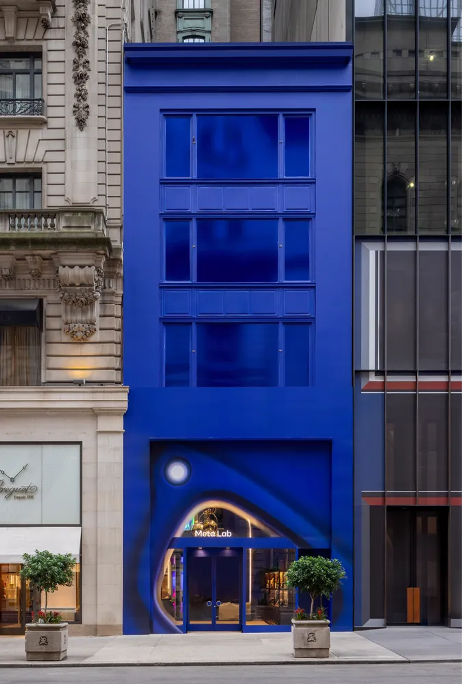 Storefront painted deep blue between pale stone buildings