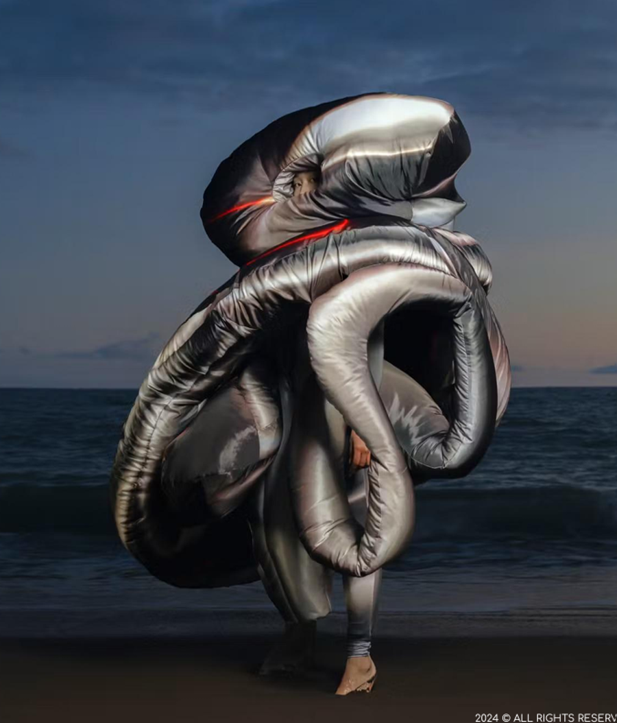 Chrome inflatable sculpture on the sand facing the sea