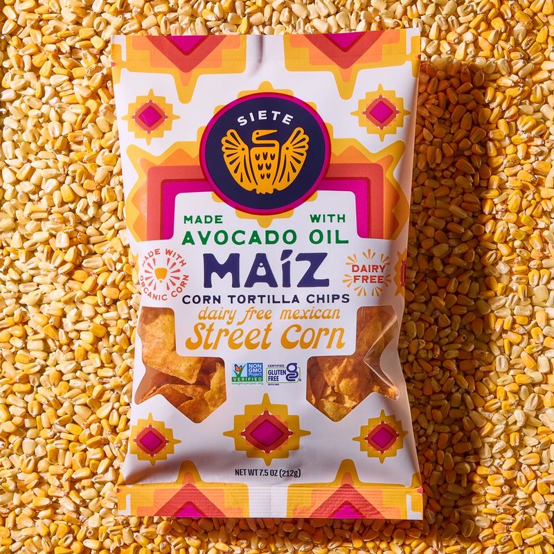a package of maiz street corn tortilla chips on a background of corn kernals