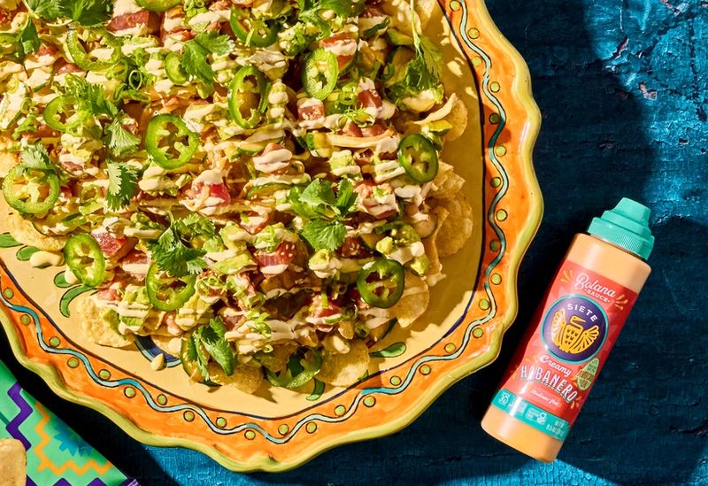 nachos with habanero botana sauce laying flat beside dish