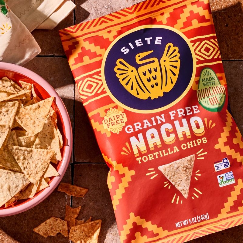 person holding a nacho tortilla chip bag