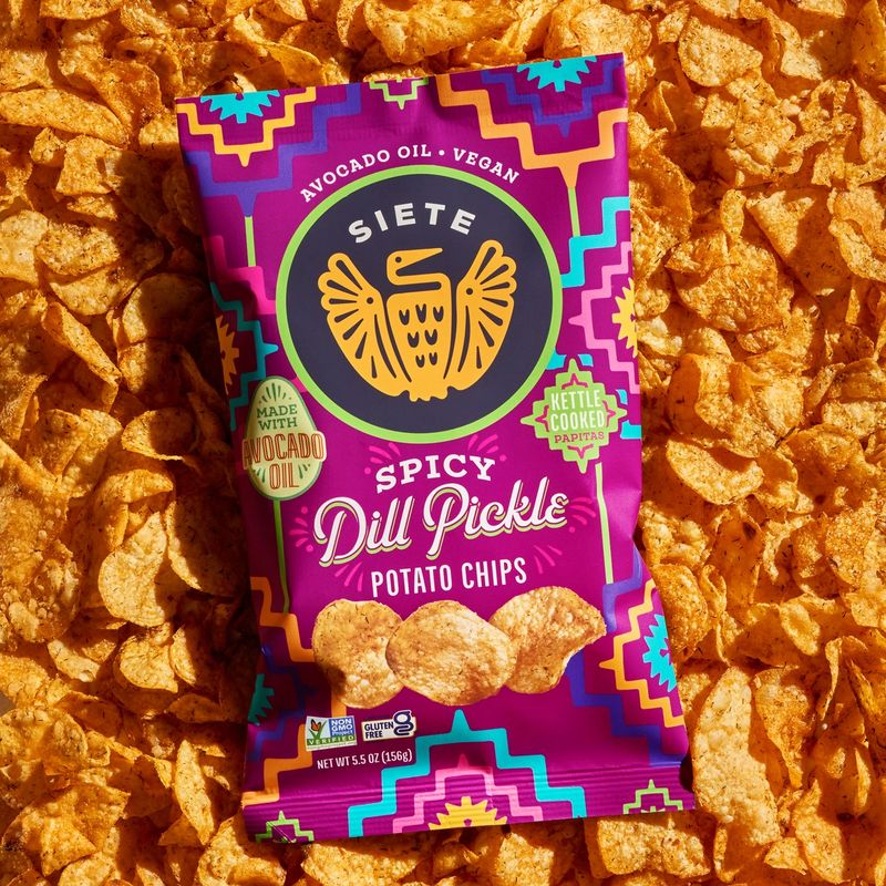 a package of Spicy Dill Pickle potato chips on a background of chips