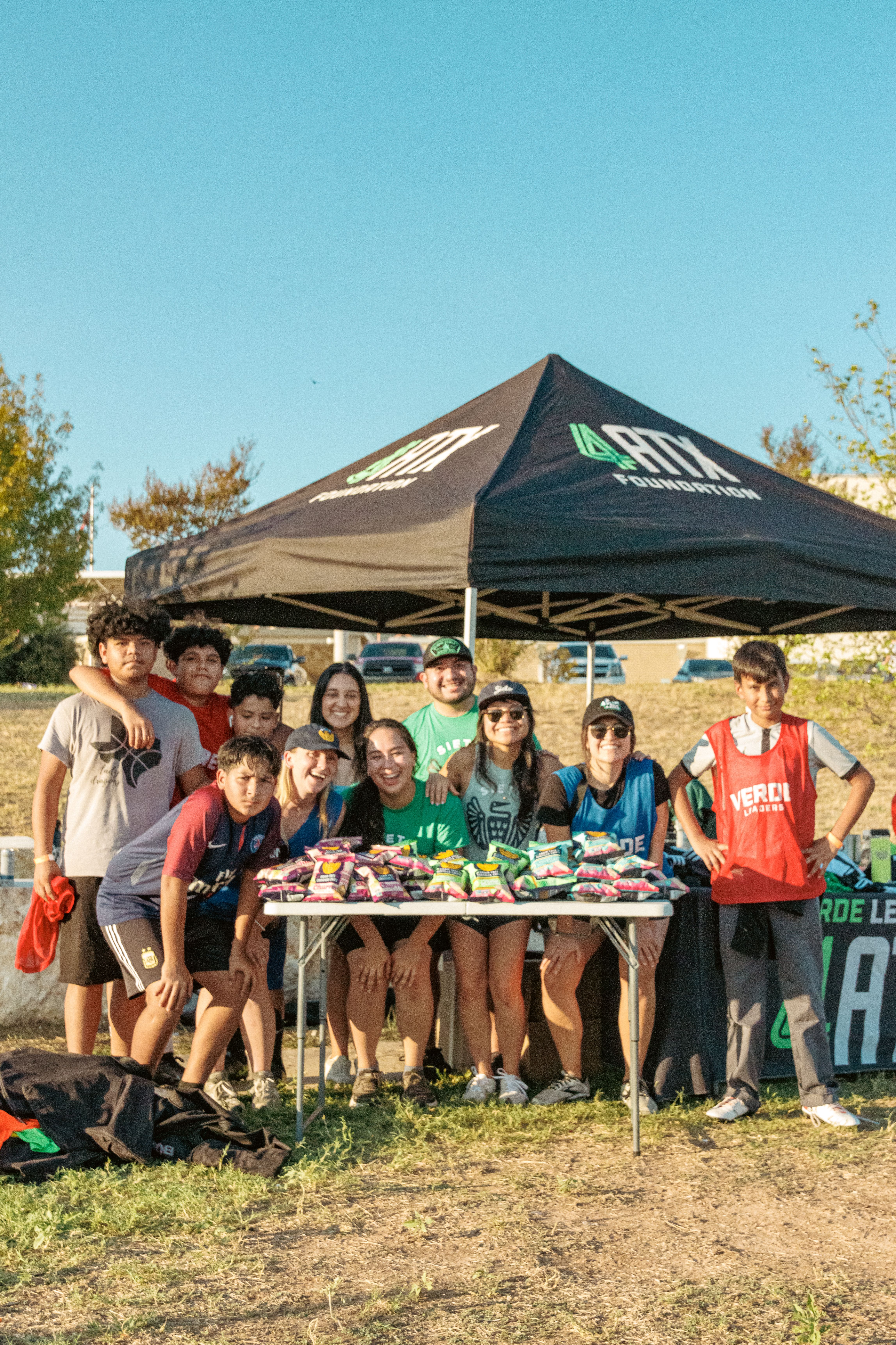 group posing on soccer pitch for 4atx foundation