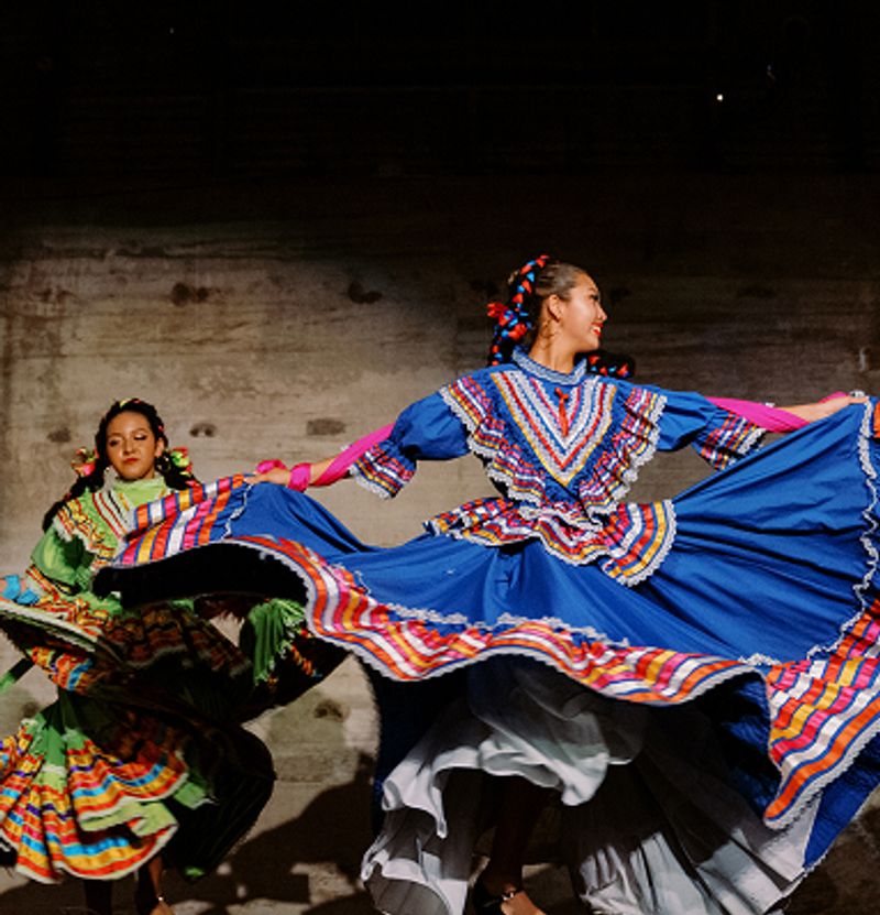 Two women dancing in traditional dresses.