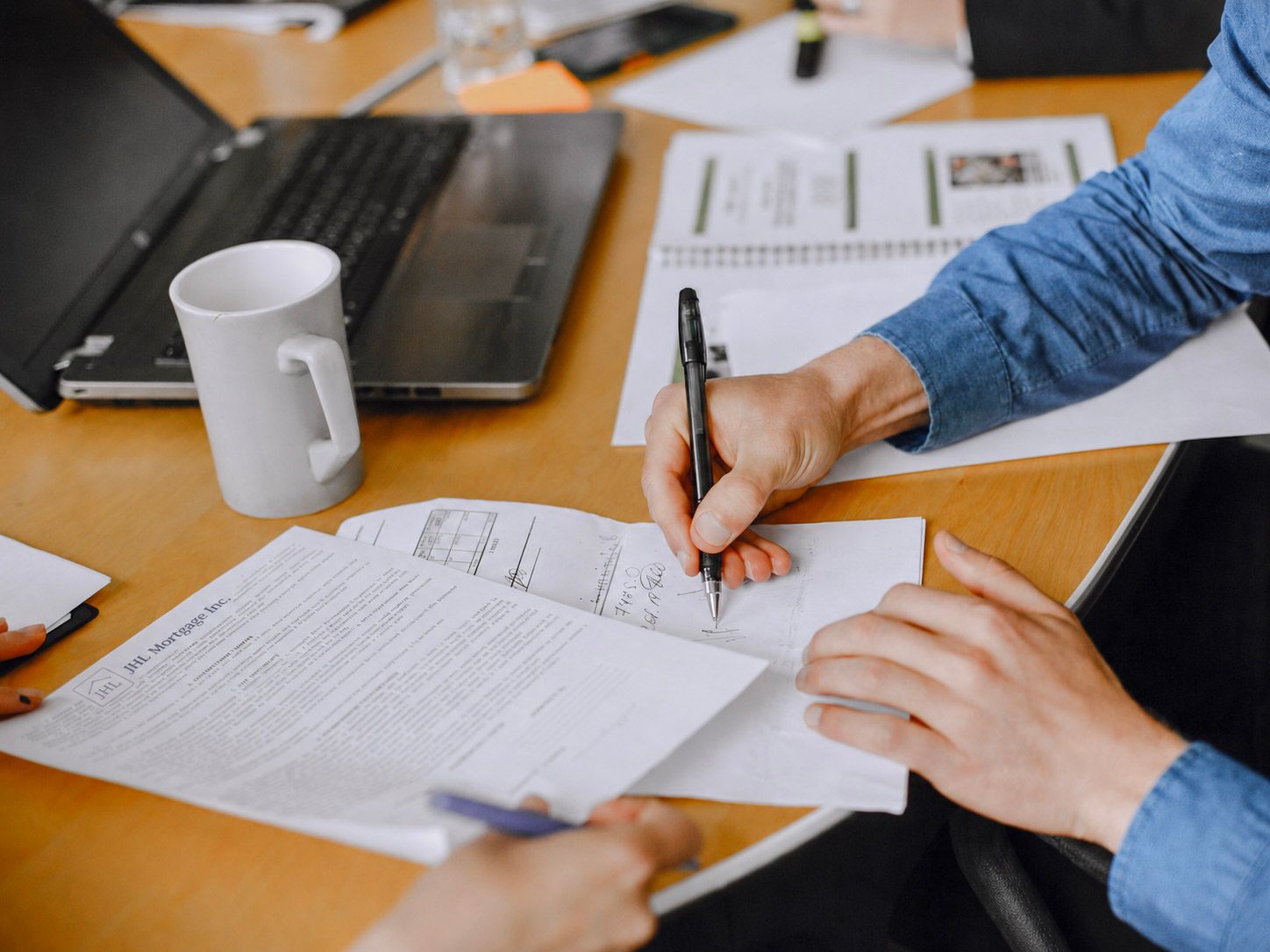 First time homebuyer signing papers with JHL loan officer.