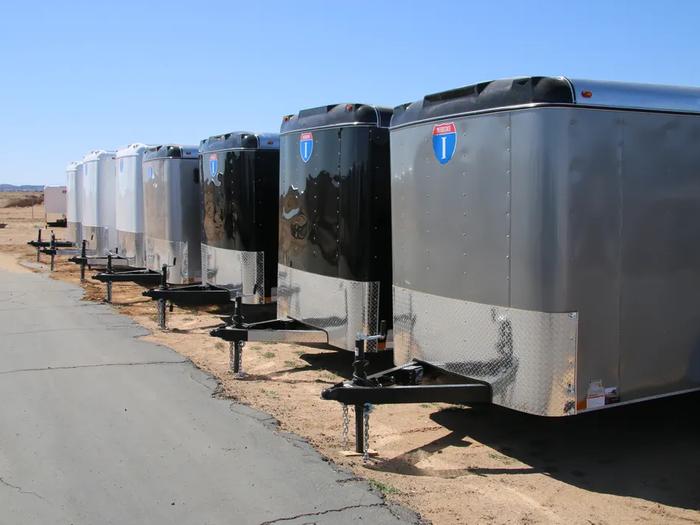 Lineup of cargo trailers with a blue sky