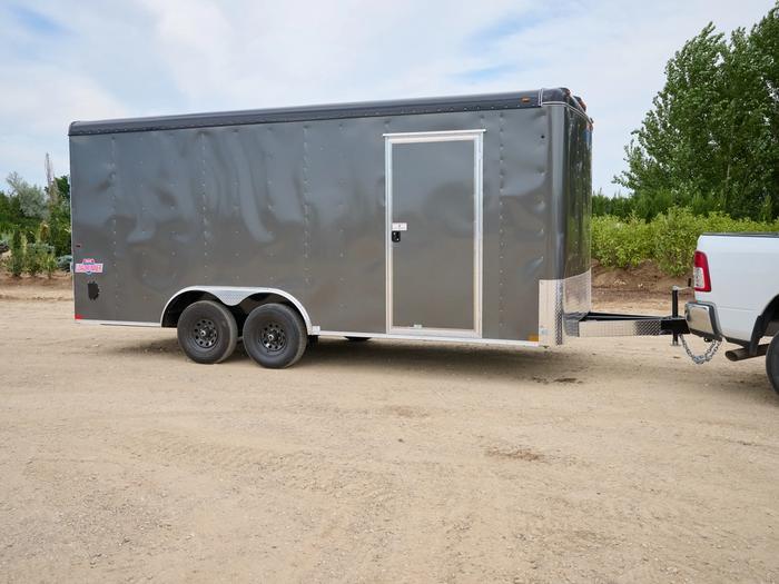 Gray cargo trailer with a side door attached to a white truck