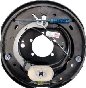 Close-up of an exploded trailer drum-brake assembly showing the backing plate, springs, and brake lines