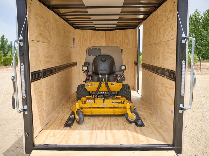 Enclosed trailer with a yellow riding lawnmower inside
